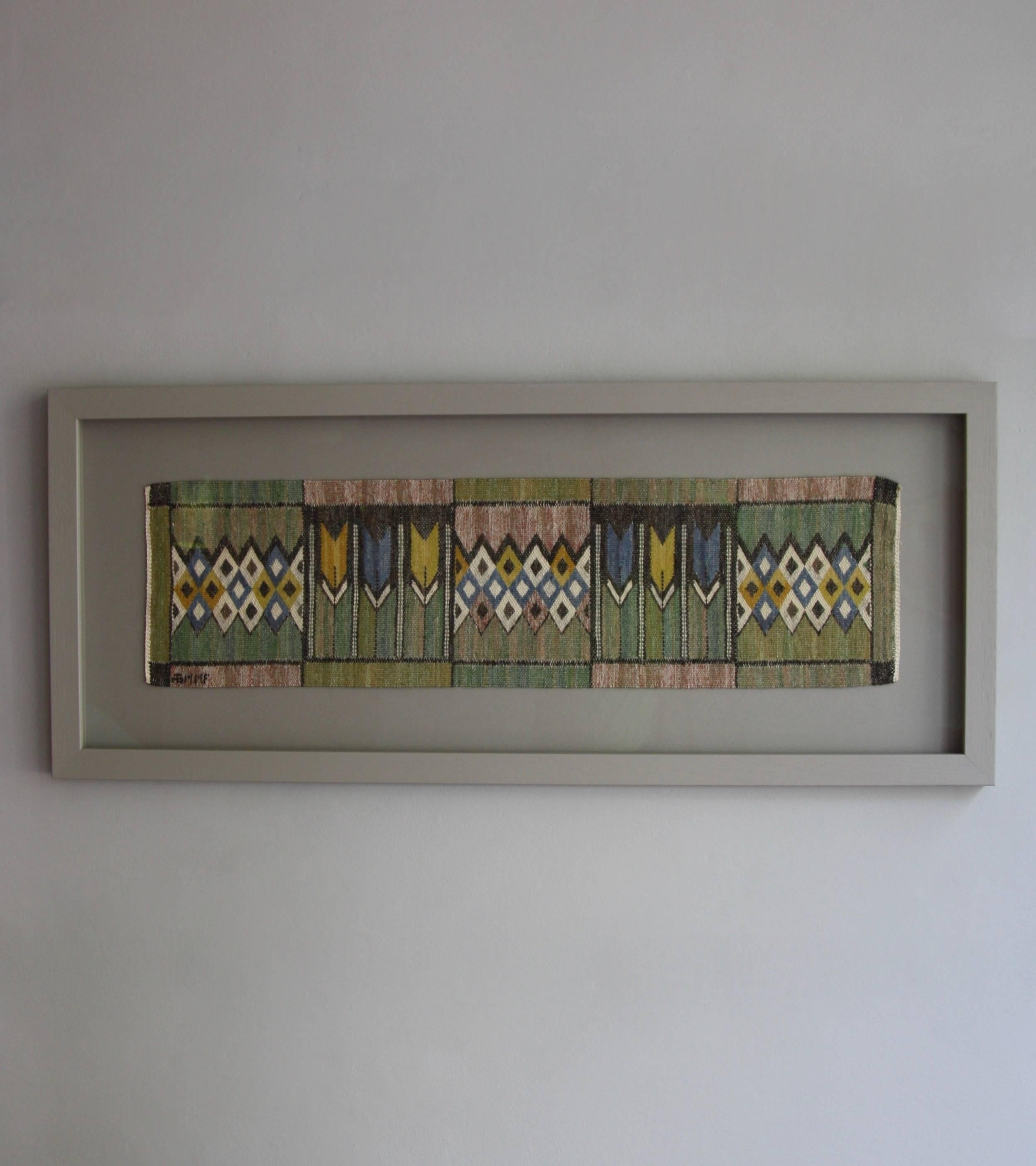 A vintage mid-20th century handwoven textile from Marta Maas-Fjetterström’s workshop in Ba°stad, Sweden, designed by Barbro Nilsson.
The tapestry features geometric diamonds and rectangles as well as six stylized tulip flowers. The symmetrical