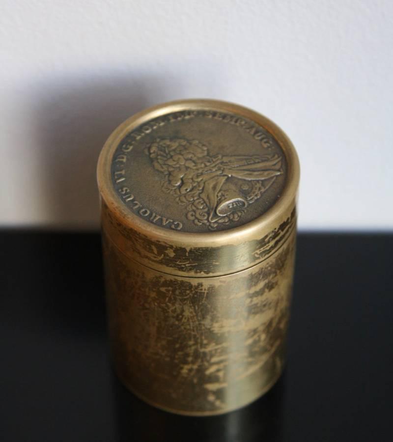 Cylindrical box in brass by the Werkstatte, Vienna, circa 1960.
The outer part of the lid features an effigy of Charles VI, Holy Roman Emperor right profile with the inscription 'CAROLUS VI:D.G.:ROM.IMP.SEMP.AUG:'. The inner part bears another