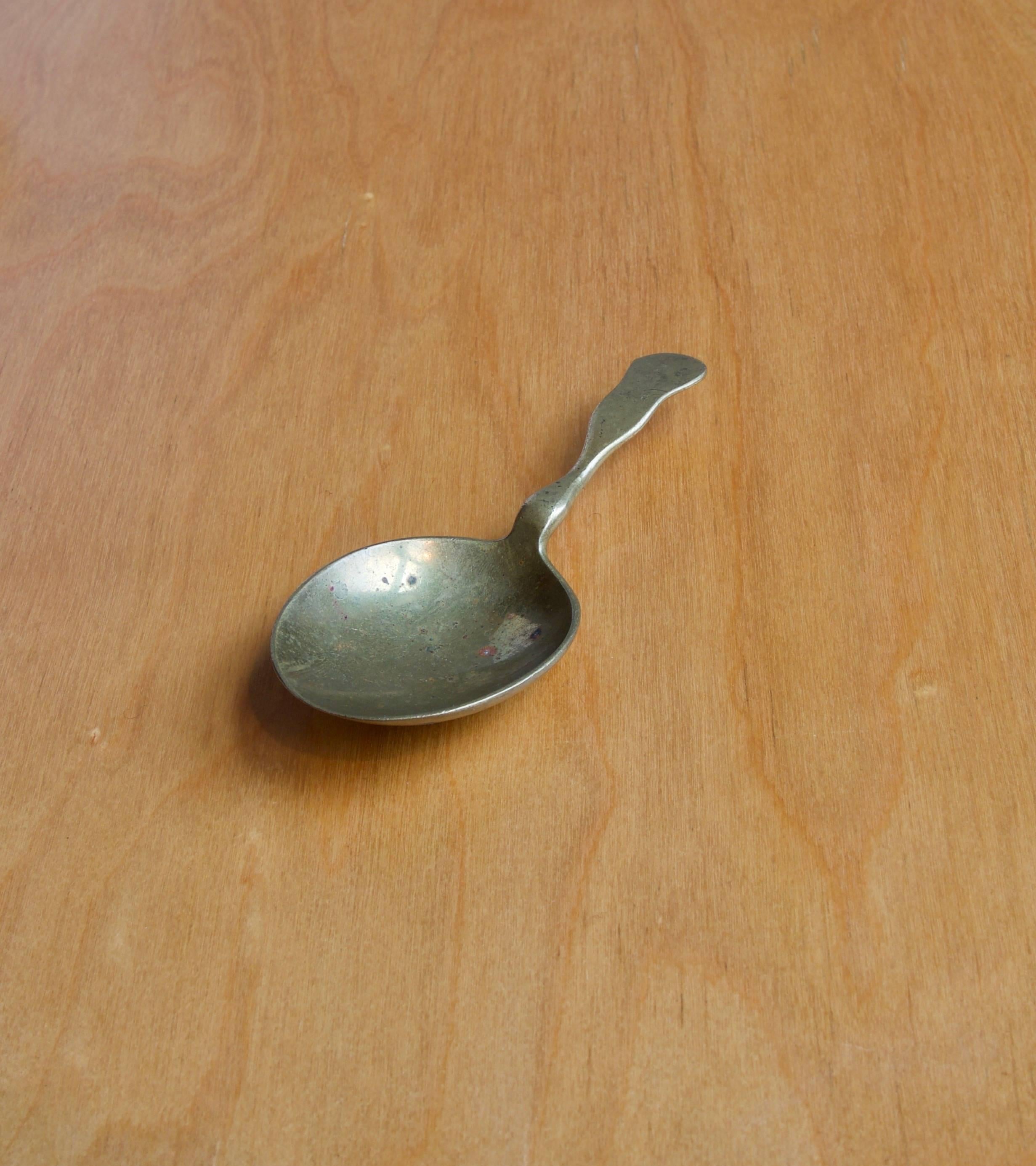 A sculptural solid cast-brass spoon, model number 4565, designed and made by Carl Auböck, Vienna.
The lines and weight of this piece make it a delight to both look at and use. The spoon is balance so that the handle floats in the air when not in
