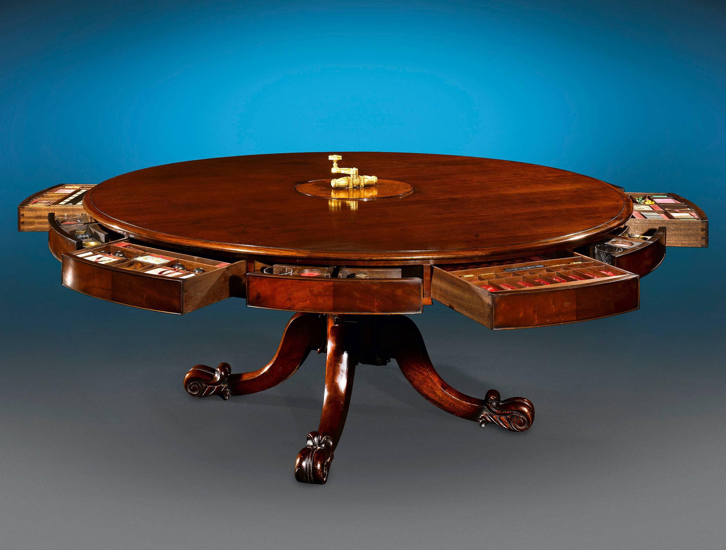 A work of extraordinary ingenuity and rarity, this Irish mechanical dining table transforms into a fully stocked games table with just a few turns. Crafted of impeccable Cuban mahogany, the table exhibits a striking patina and a beautifully sculpted