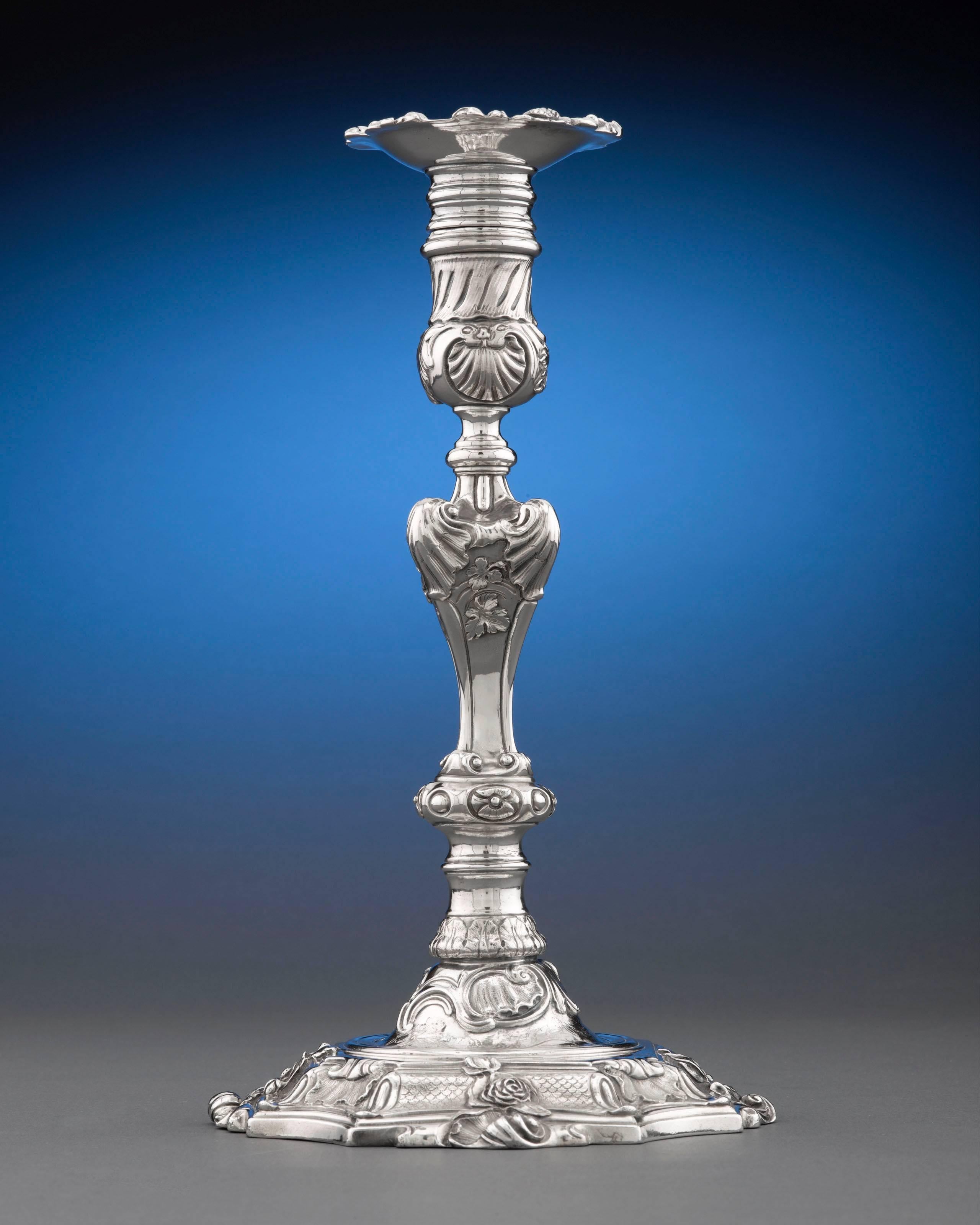These spectacular George II-era silver candlesticks were created by celebrated English silversmith Paul de Lamerie. Made for a member of the notable Duncombe family of Yorkshire, these majestic candlesticks feature an elaborate Rococo motif that is
