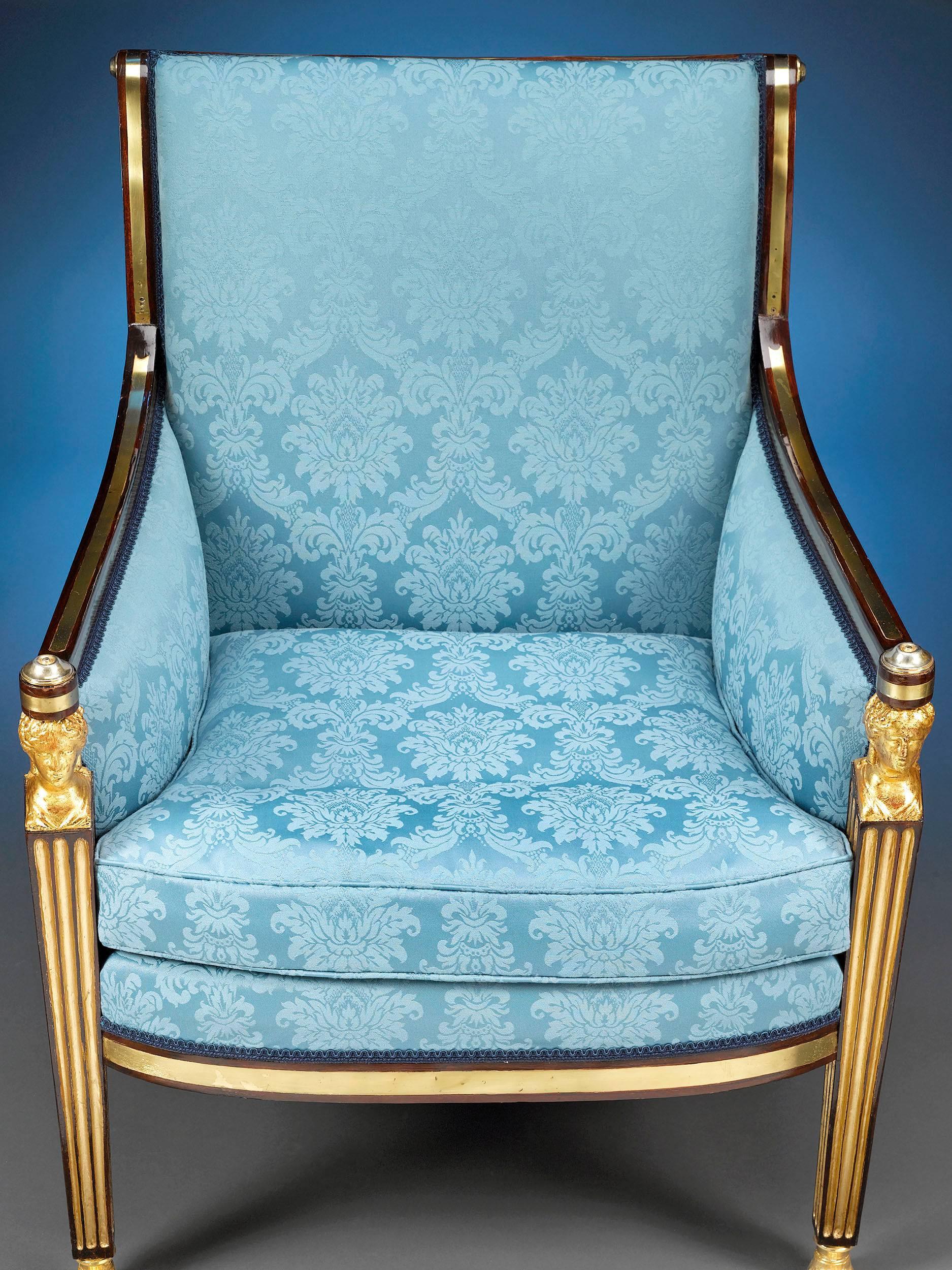 This elegant armchair exemplifies the gracious Regency style. Adorned with luxurious upholstery on the back, seat and sides, this enchanting chair boasts classically inspired elements, from the gently scrolling back and gilt bronze accented arms to