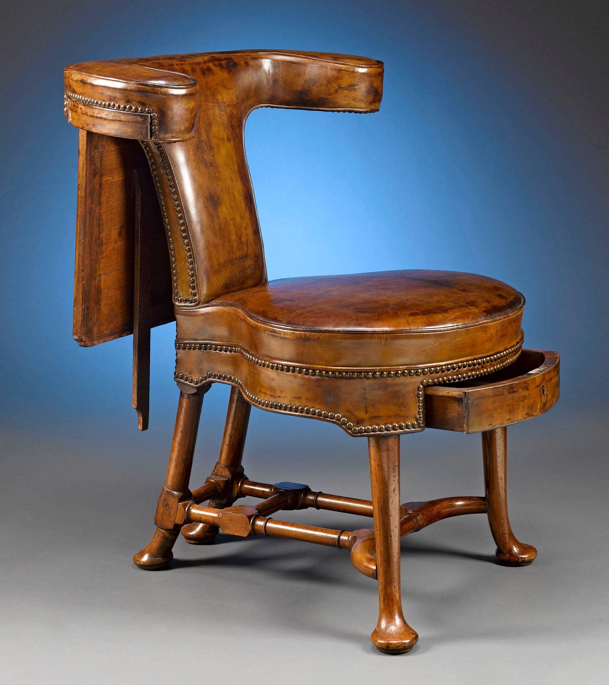 This splendid George II-period reading chair is stunning in both form and quality. Crafted of rare walnut, the marks of an early Georgian piece, this intriguing leather-upholstered seat features a yoke-shaped top rail with an adjustable easel and a