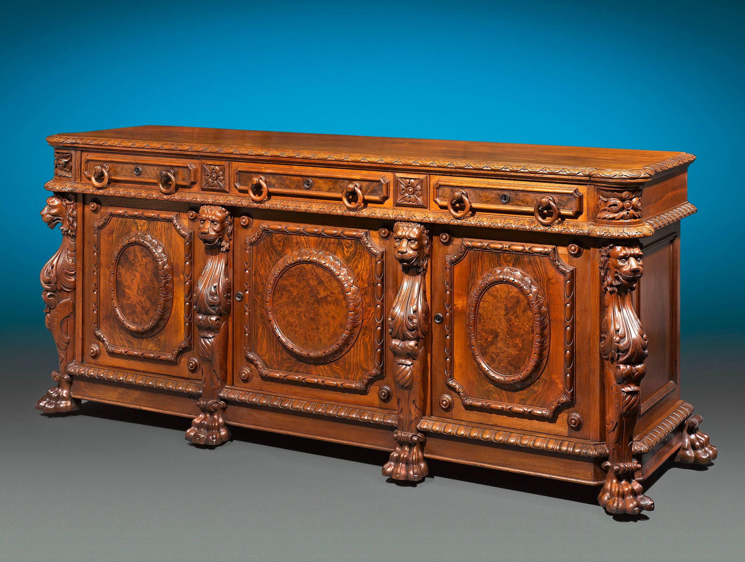Sumptuous carvings distinguish this fine 19th century American walnut sideboard. Crafted in the Renaissance style, this grand furnishing boasts four beautifully hand-carved lion masks terminating in paw feet, gadrooned detailing and circular patera