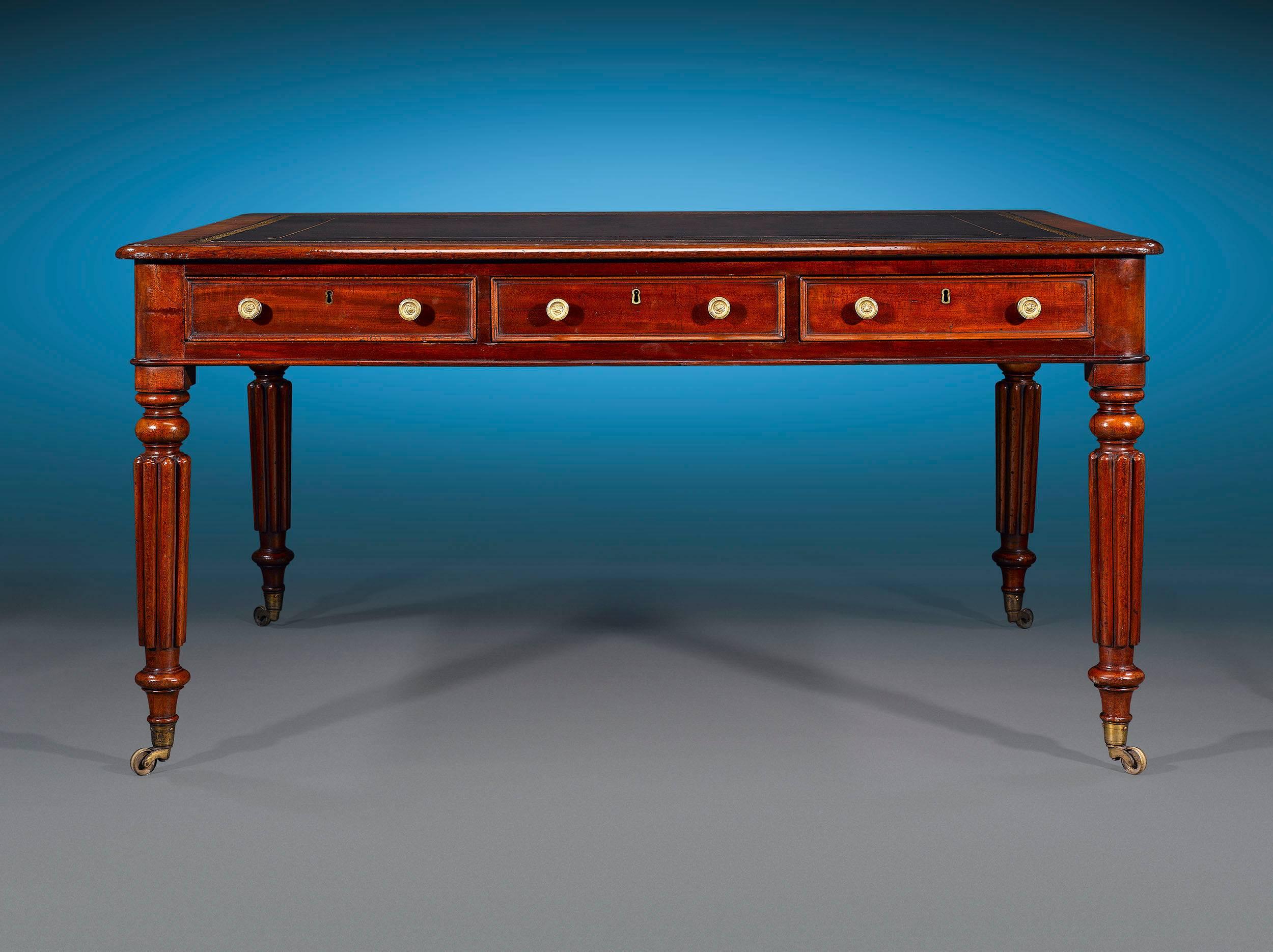 This timeless and rare William IV partner's writing table is the essence of English neoclassical furniture design. Crafted of luxurious Cuban mahogany, this elegant desk features an inset leather top, three drawers in the frieze for storage, and