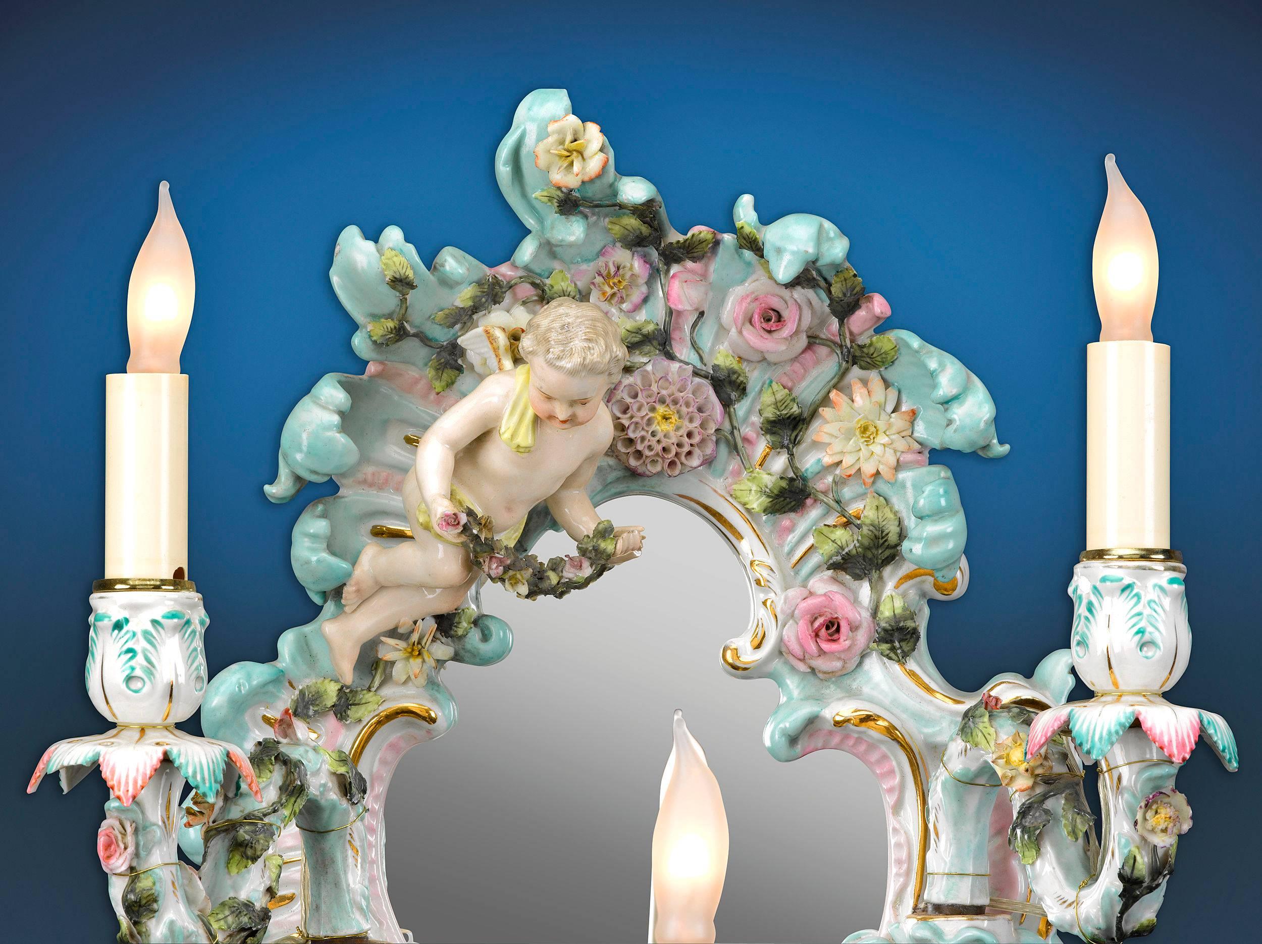 This magnificent Meissen-style porcelain wall sconce features three candle holders and is adorned with hand-painted, floral Rococo decoration.

circa 1870.

Measures: 14 1/4