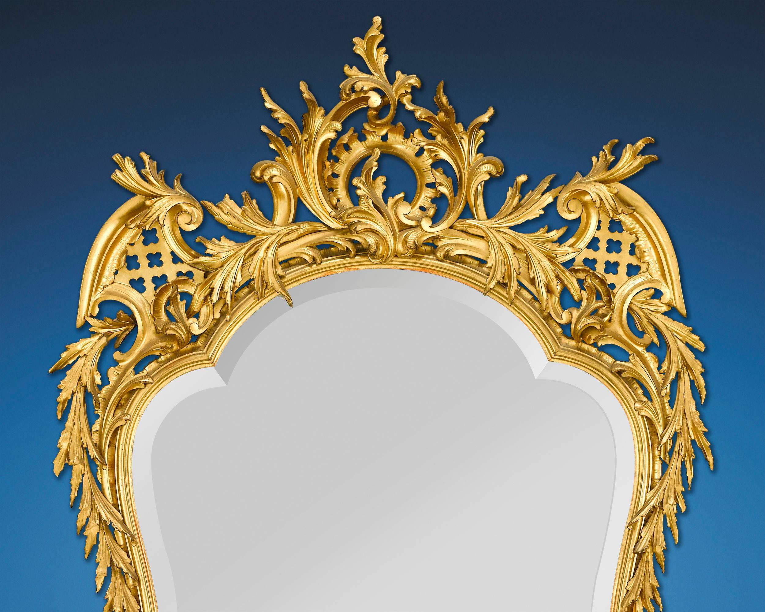 This phenomenal Louis XV style French mirror features an elegant shape and an undulating, intricately carved giltwood frame. Composed of flawless beveled glass, this mirror is a study in Rococo glamour, with its asymmetrical, foliate decoration of