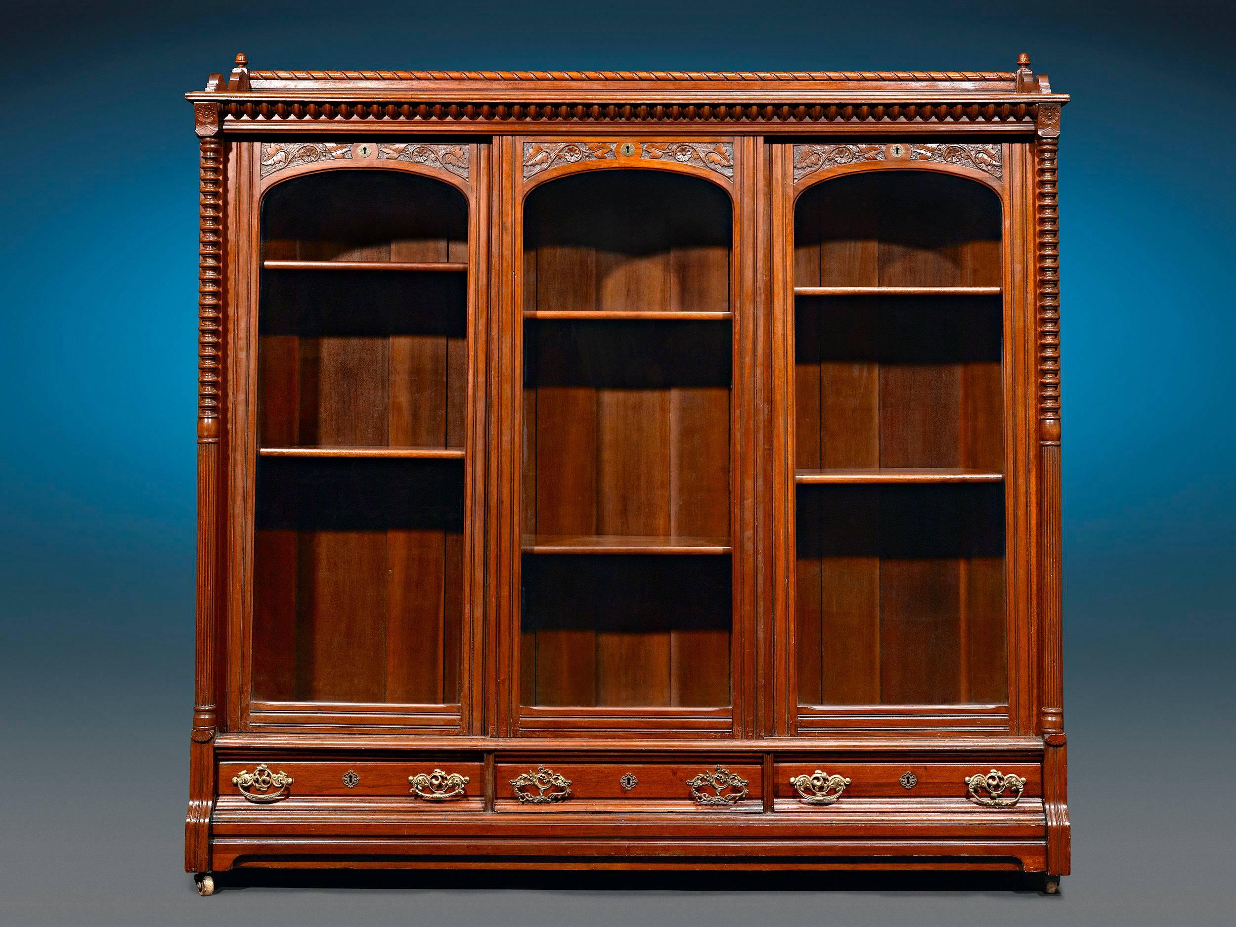 Crafted of luxurious mahogany, this magnificent English bookcase captures the elegance of the Victorian period in grand style. Balanced and beautifully proportioned, the exceptional cabinet is perfect for displaying one's most prized texts and