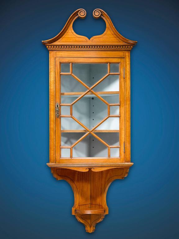 A beautiful pair of satinwood corner curio cabinets crafted in the Chippendale manner with broken pediment top, glass door inserts and highly detailed molding,

circa 1890.