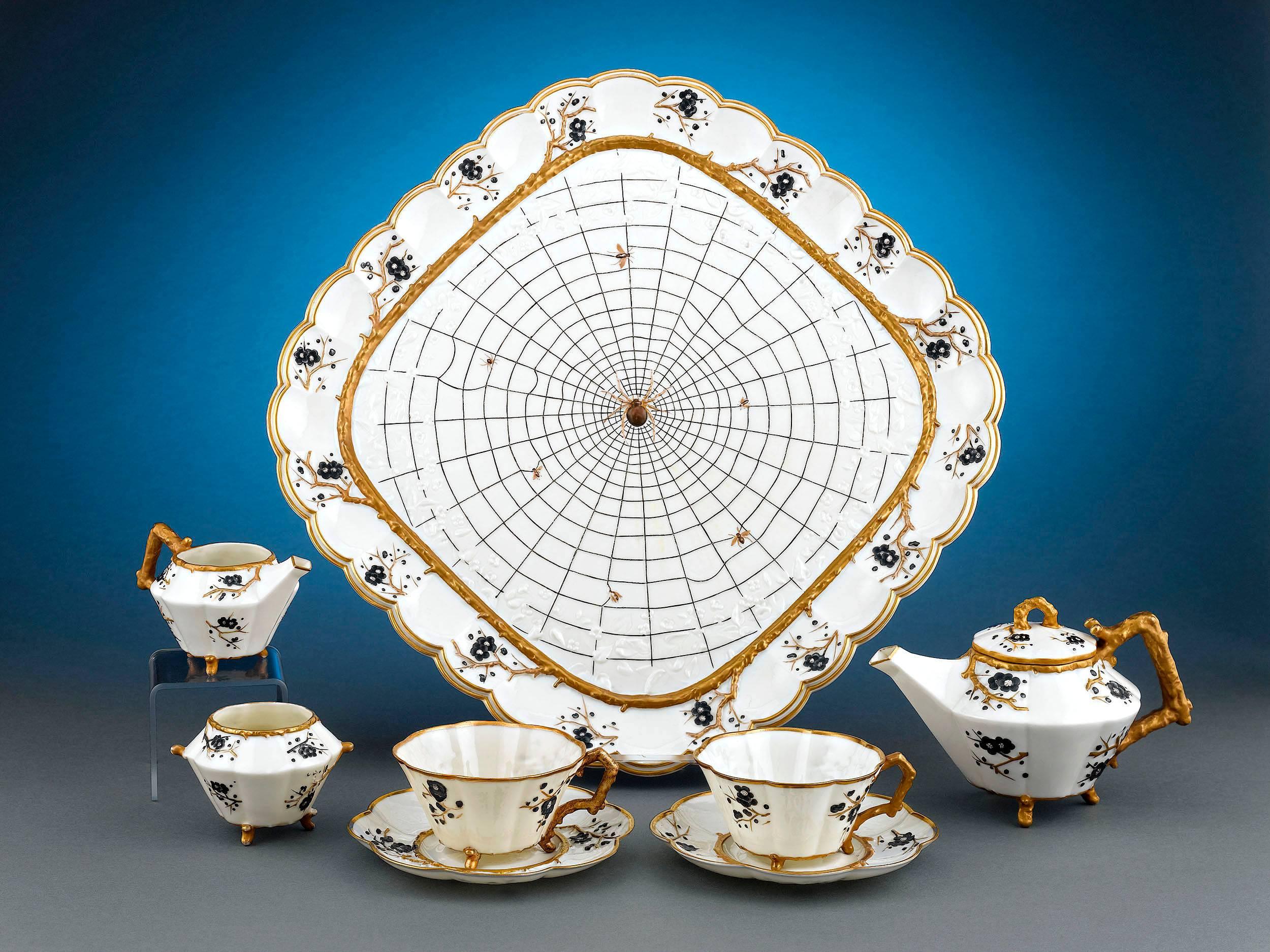 This delightful and rare Belleek dejeuner tea set exhibits the intriguing Thorn pattern. Comprised of a teapot, creamer, sugar bowl and two teacups and saucers, all set upon a square spider web tea tray with a scalloped rim, this delicate service