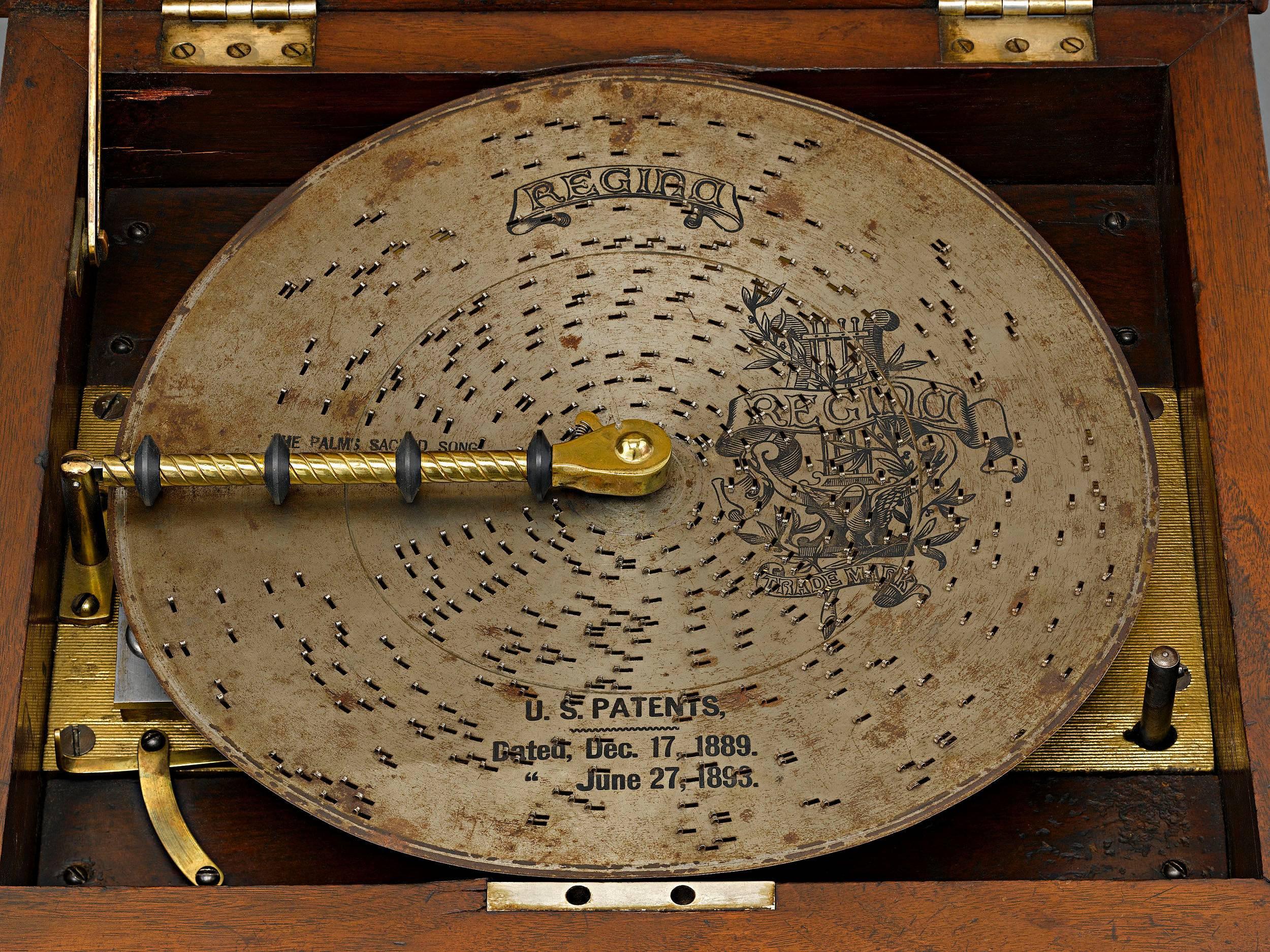 The Regina Music Box Company of New York crafted this wonderful interchangeable disk music box with one of its most ornately carved walnut cases. The box, known as Style 19 plays 11 disks with a double-comb mechanism and retains the incredible sound