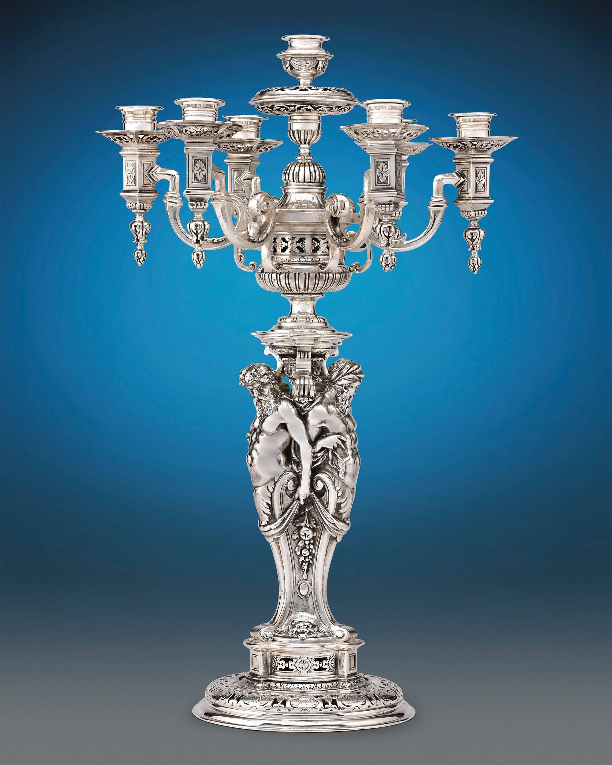 Beautiful specimens of Renaissance Revival design, this regal pair of silver plated candelabra were crafted by the legendary Parisian silver firm of Puiforcat. Majestic pierced and architectural elements distinguish the pair's design, which is