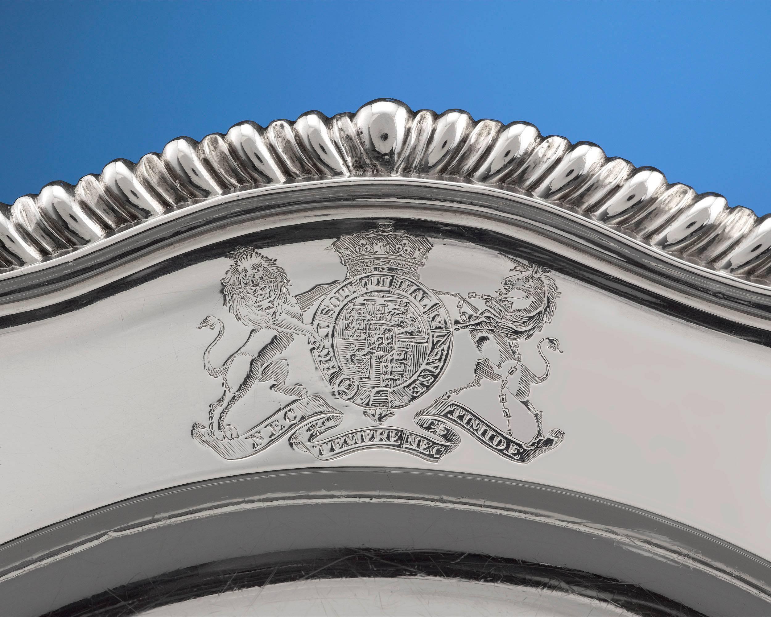 The royal coat of arms is majestically displayed on these beautiful silver plates by highly-regarded London silversmith William Elliott. The plates are skillfully fashioned with gadrooned and scalloped edges. Of particular interest is the coat of