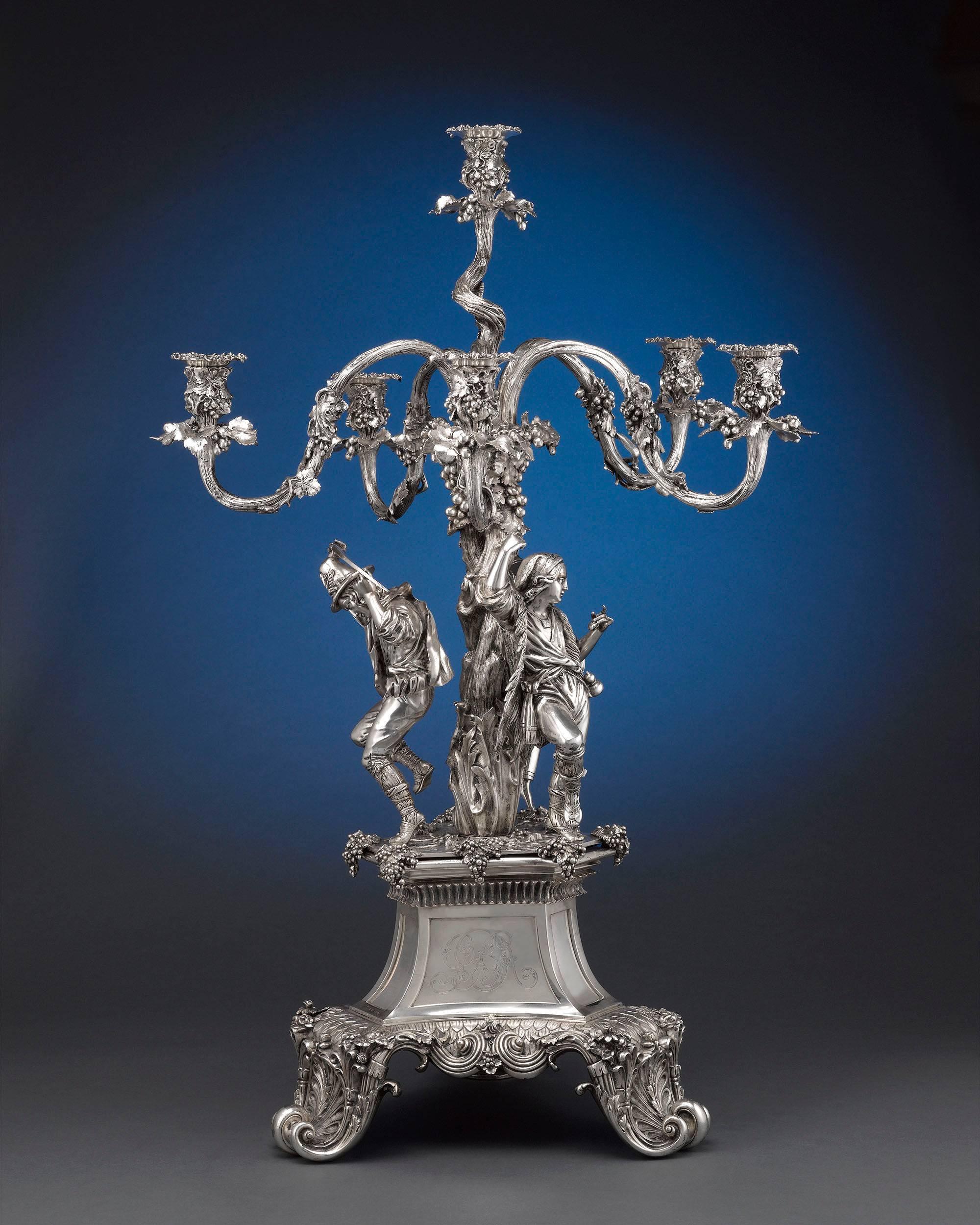 This magnificent silver plate candelabra by the acclaimed Elkington, Mason and Co., masters of silver plating, celebrates the fruits of the harvest. Intricately decorated arms form a grape vine canopy laden with fruit, under which three pastoral