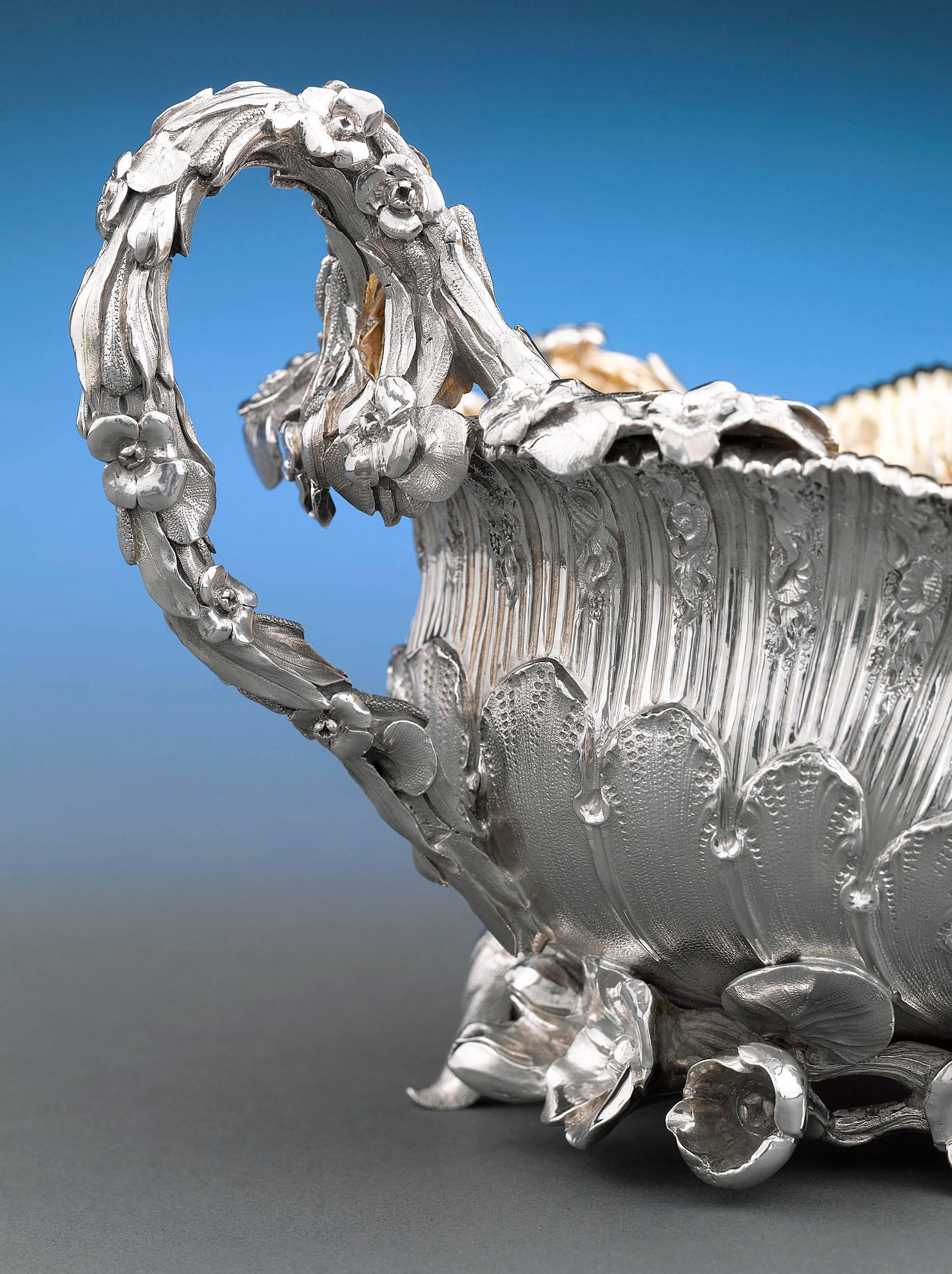 This exquisite George IV period silver sugar bowl by the celebrated Benjamin Smith is crafted in an exuberant Rococo style. From the floral and foliate handles to the delicately engraved armorial, this is a work of true genius. A gilt