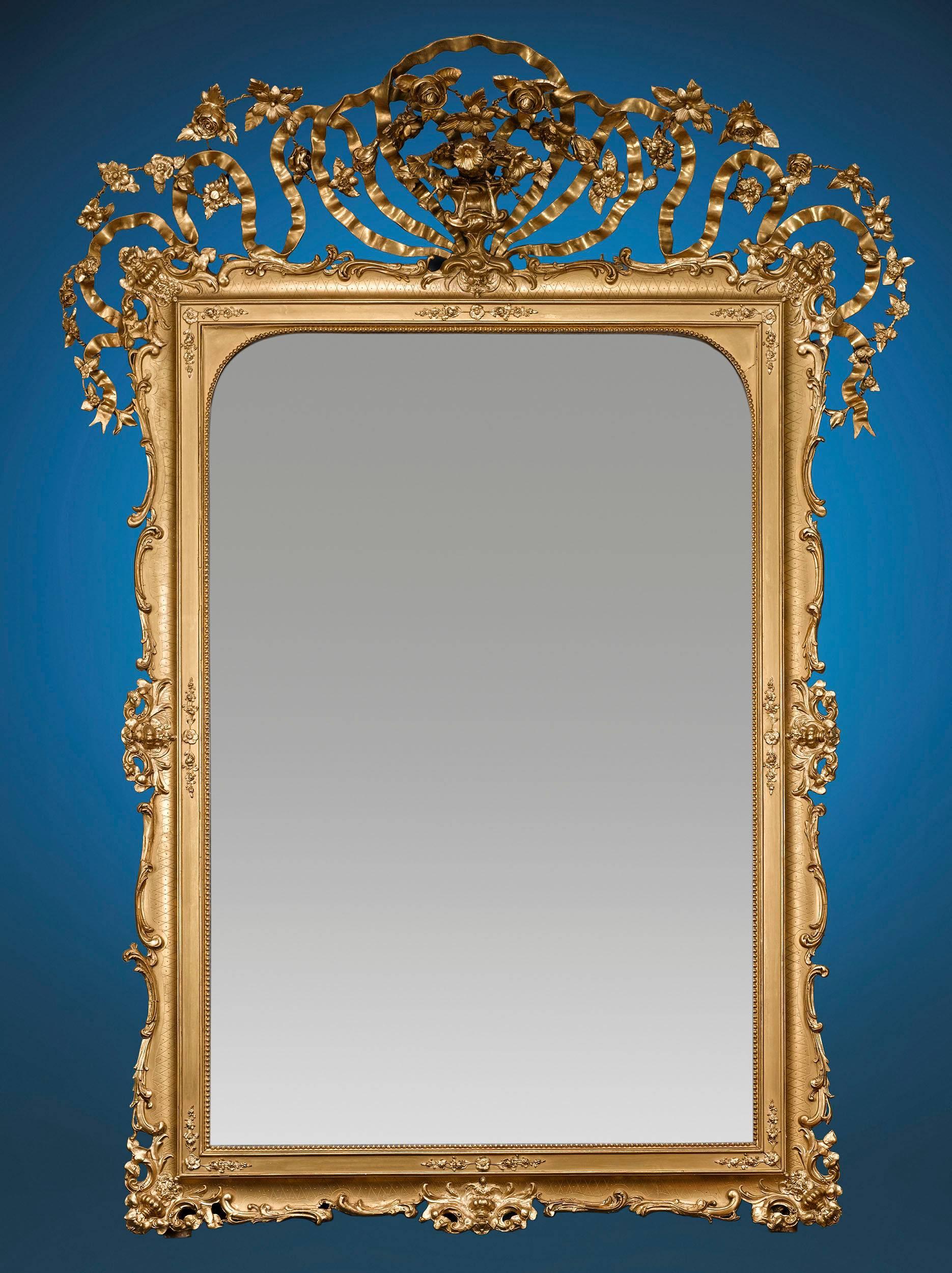Grand size and elaborately hand-carved frames set these exceptional Napoleon III-period mirrors apart. The rare pair feature their original gilding and intricate floral elements inspired by classical design. From their magnificent size to their