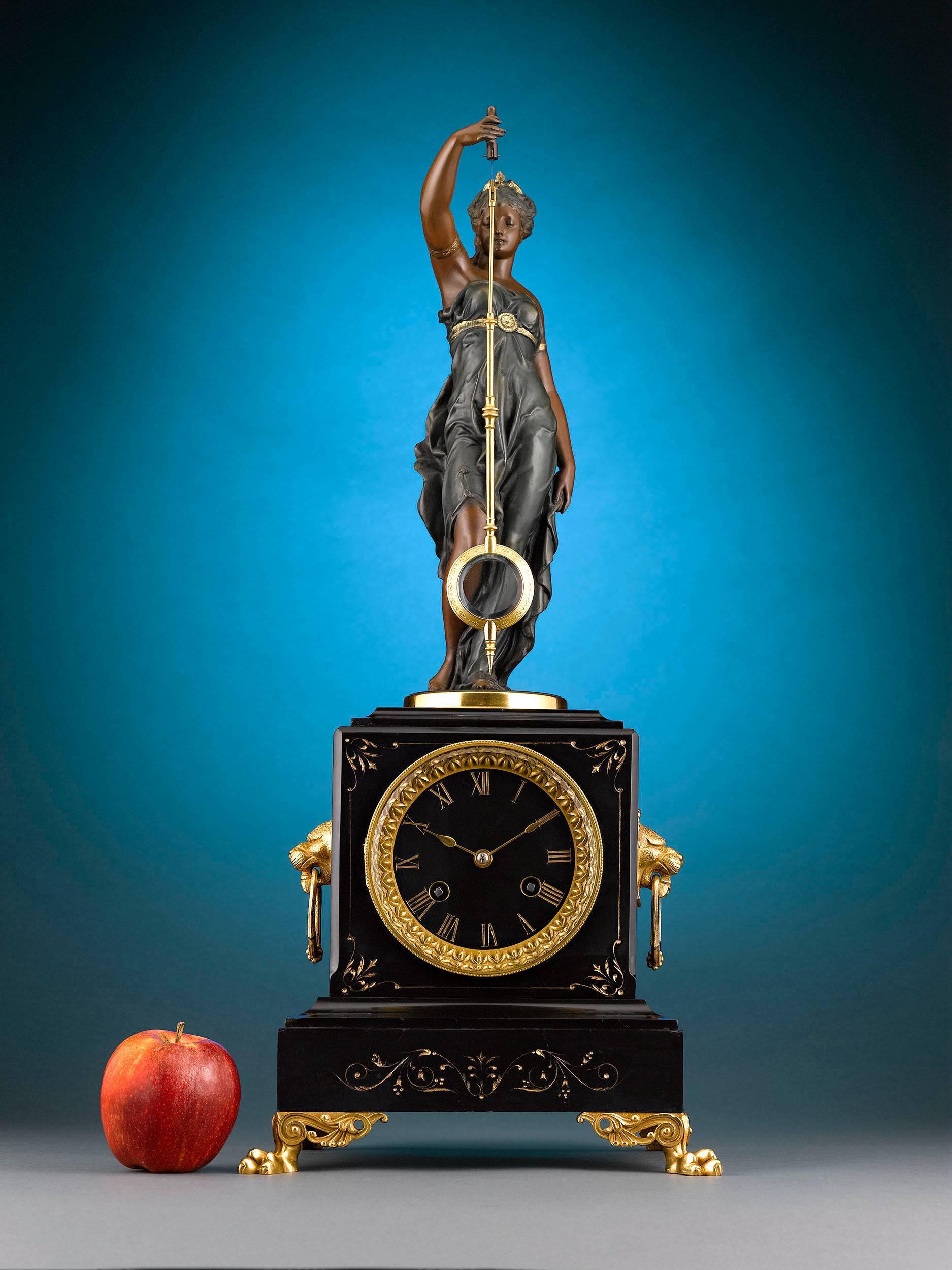 This stunning French mystery clock by A.R. Guilmet is a delight to behold, combining captivating artistry with mechanical genius. The patented bronze figure stands upon a black slate base, holding the pendulum above the intricate spring-driven