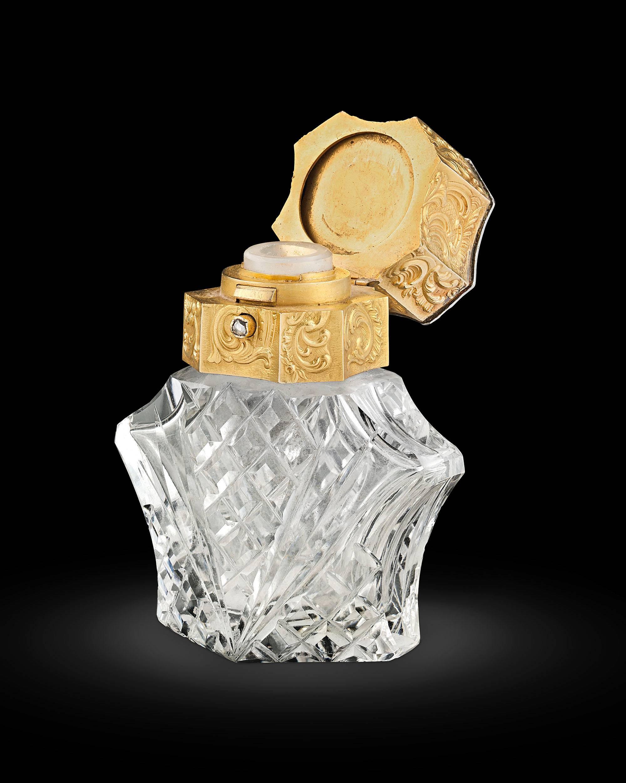 The quintessence of luxury, this opulent French crystal bottle is an exquisite objet d'art. Masterfully crafted from crystal, the piece is topped by a stunning 24k gold lid covered in an elaborate scrollwork design. A dramatic Siberian amethyst
