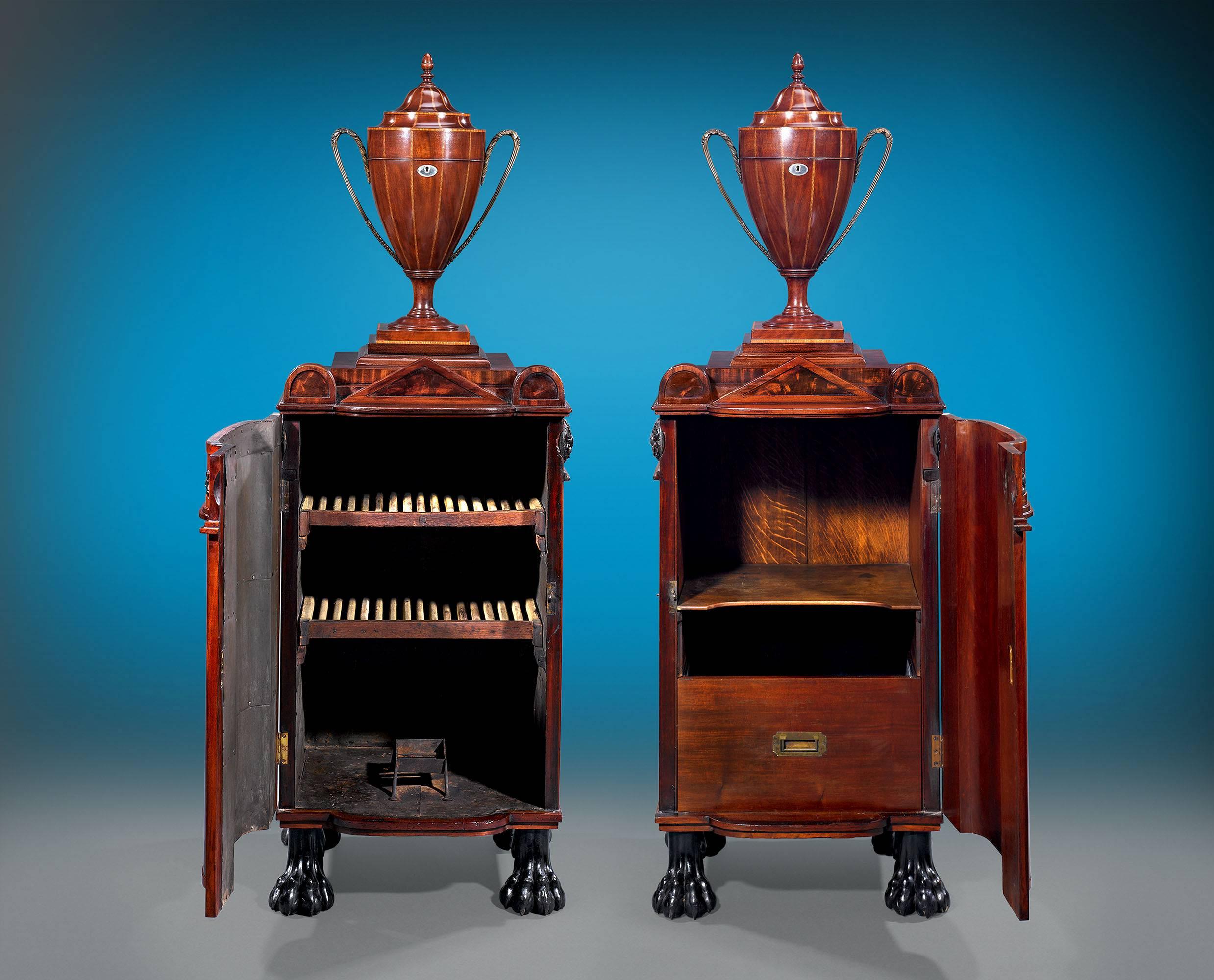 These Regency-period dining pedestal cupboards are executed in the manner of the renowned English furniture designer, George Smith. Much more than meets the eye, these distinguished mahogany pedestals actually serve as a dish warmer and wine