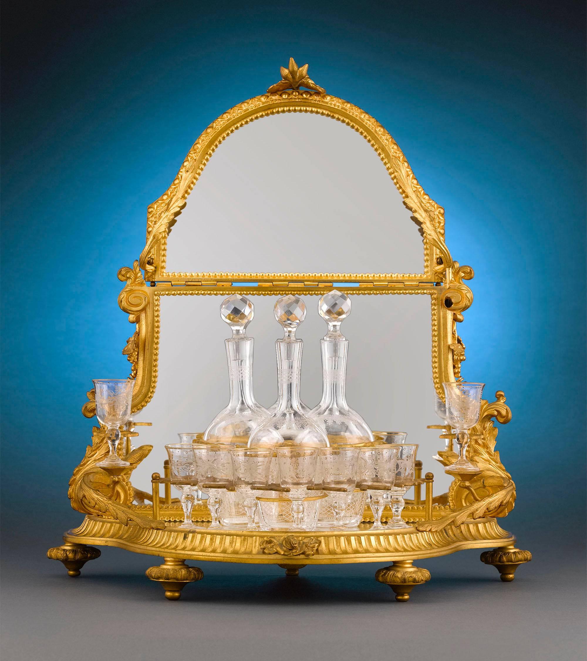 This rare and stunning cave à liqueur is crafted of beautifully detailed doré́ bronze in the form of a canopy. When locked, the canopy secures the three crystal decanters. A turn of the key allows the canopy to lift, giving access to the libations