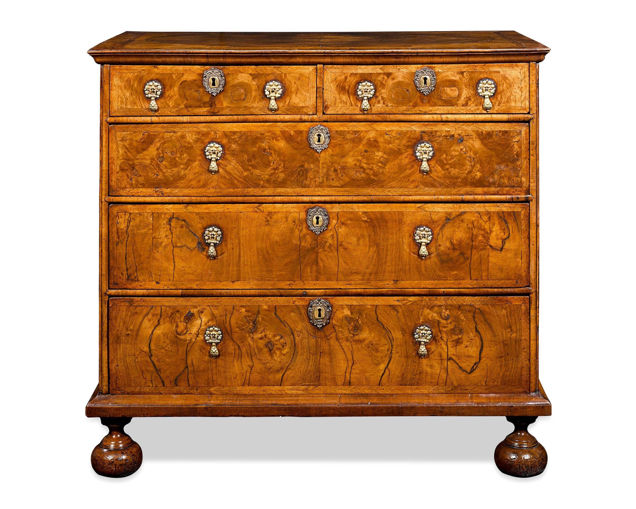This magnificent and extremely rare burl walnut veneered chest dates to the William and Mary period. Light dances across the veneers have aged to exhibit a rich and warm patina. Elevated on bun feet, the chest's exceptional design also incorporates