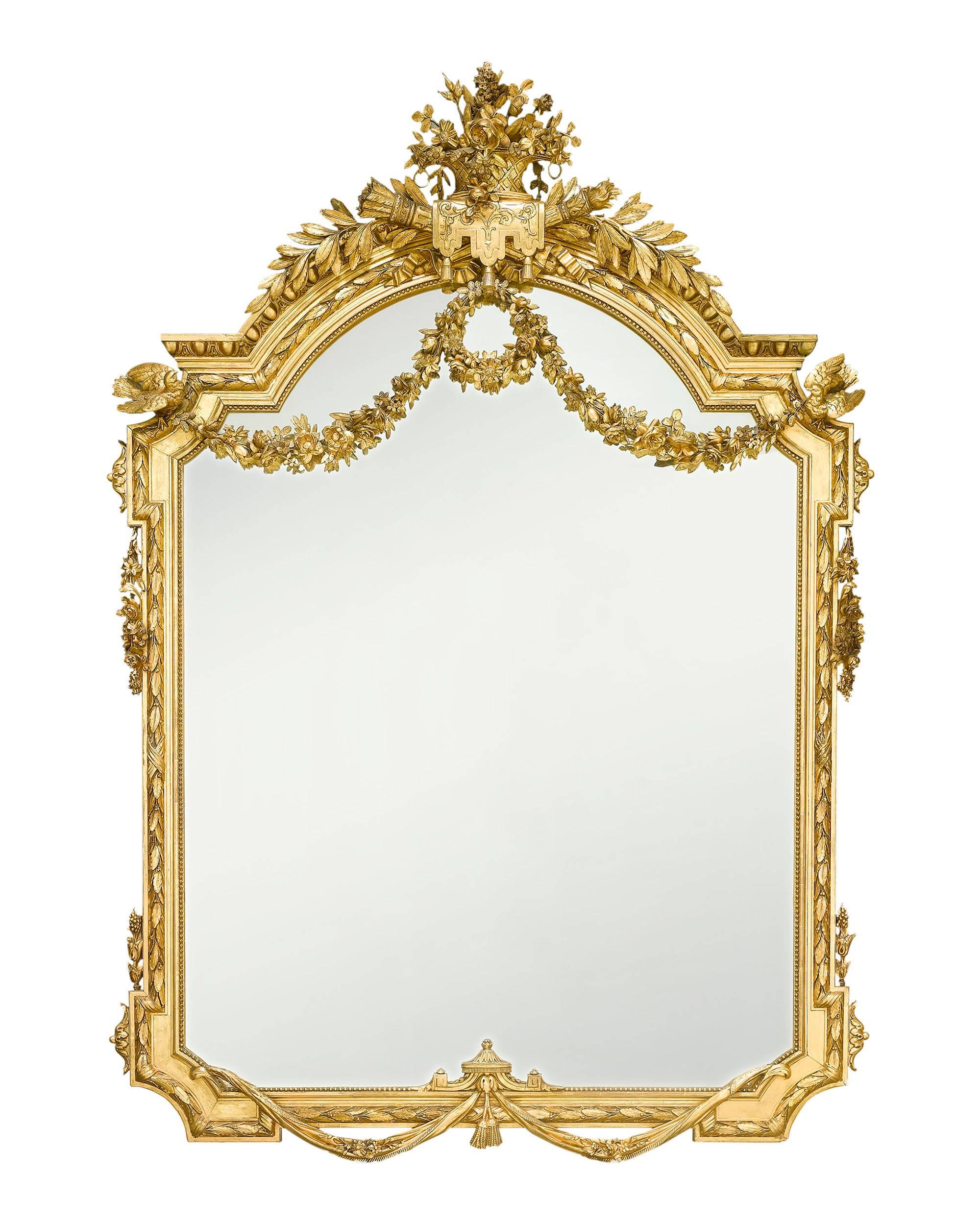 Grand in size and decoration, this exceptional Napoleon III-period mirror is further set apart by an elaborate giltwood frame that features decorative elements such as garlands, doves, a basket of flowers and Apollo's torch. The magnificent size,