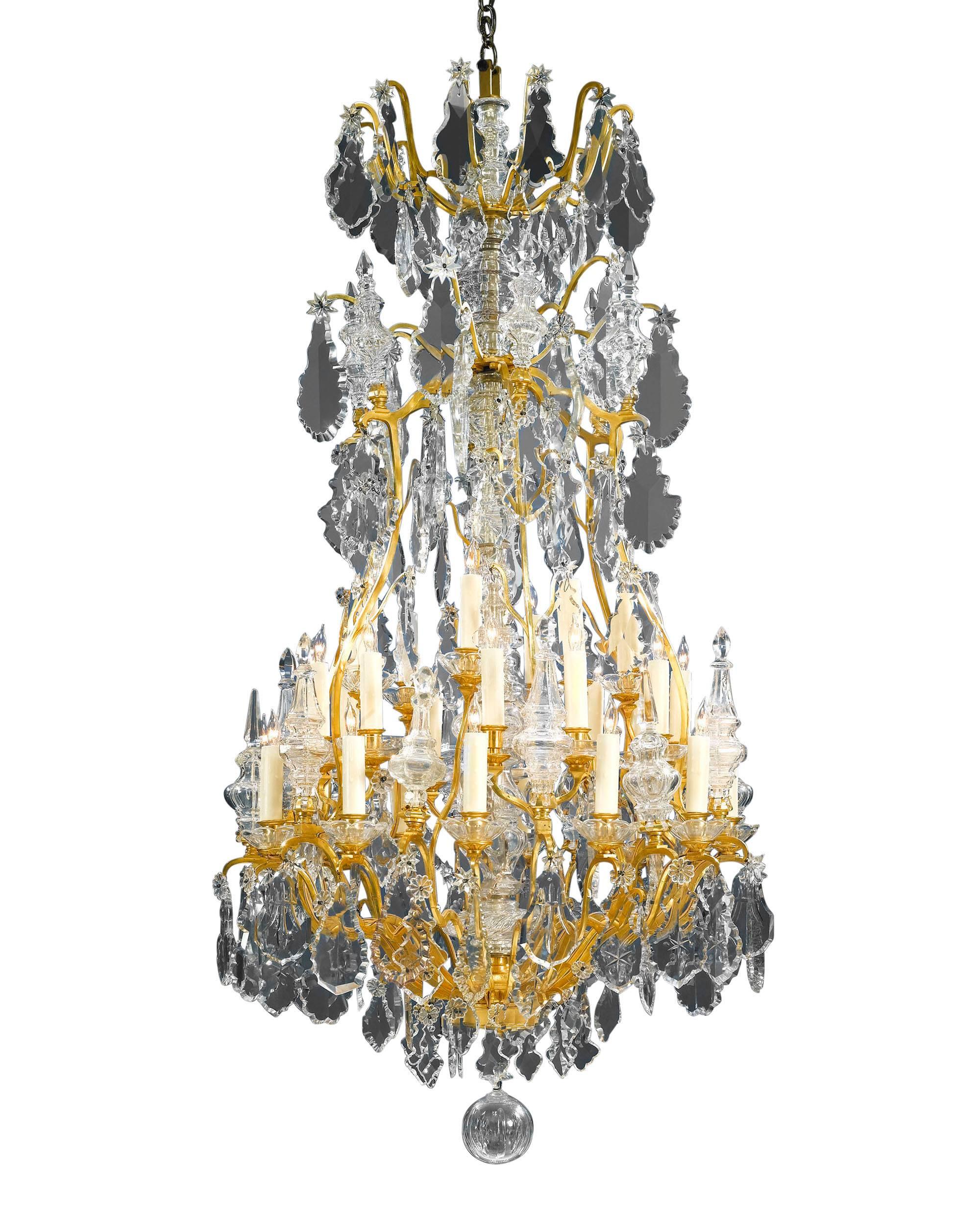 This Baccarat crystal and doré bronze chandelier is a grand sight to behold. Hundreds of beautifully designed oversized, luminous prisms and beads of hand wood-polished Baccarat crystal hang from scrolling branches of doré bronze. This thirty-light