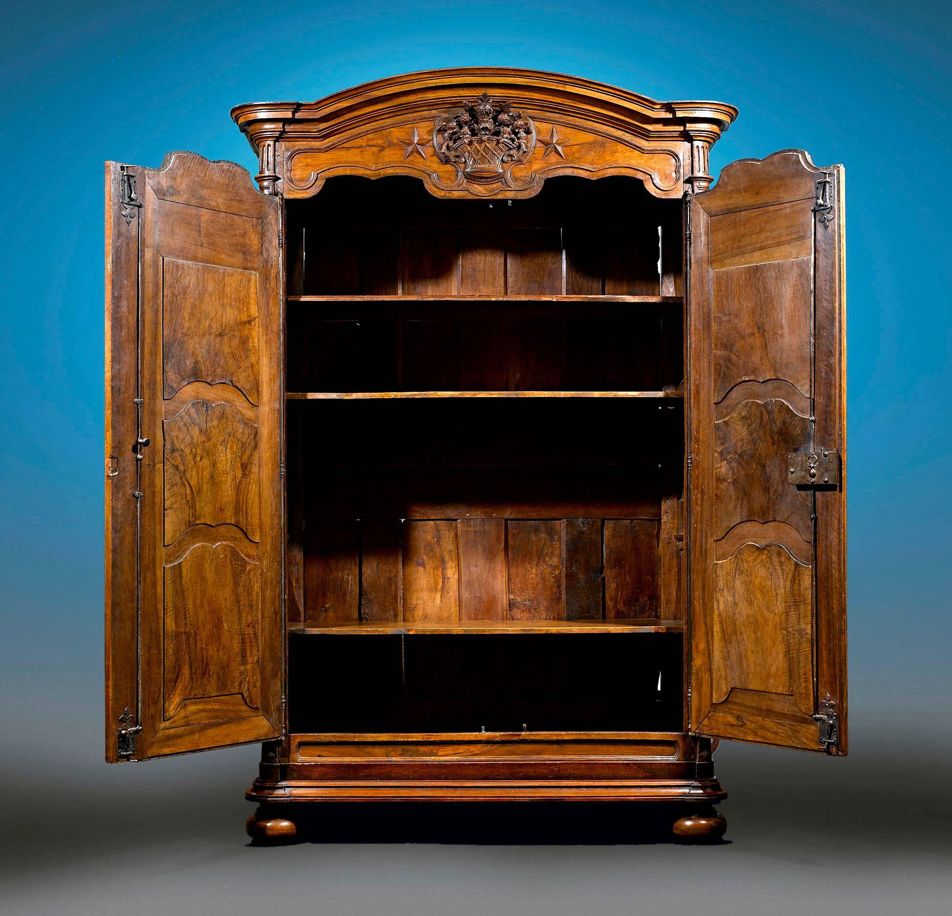 This monumental Louis XV armoire exhibits the rare beauty of French Provincial furniture. Crafted of lustrous walnut, this armoire features double doors, one of which opens with the original key, while the other opens with an interior latch.