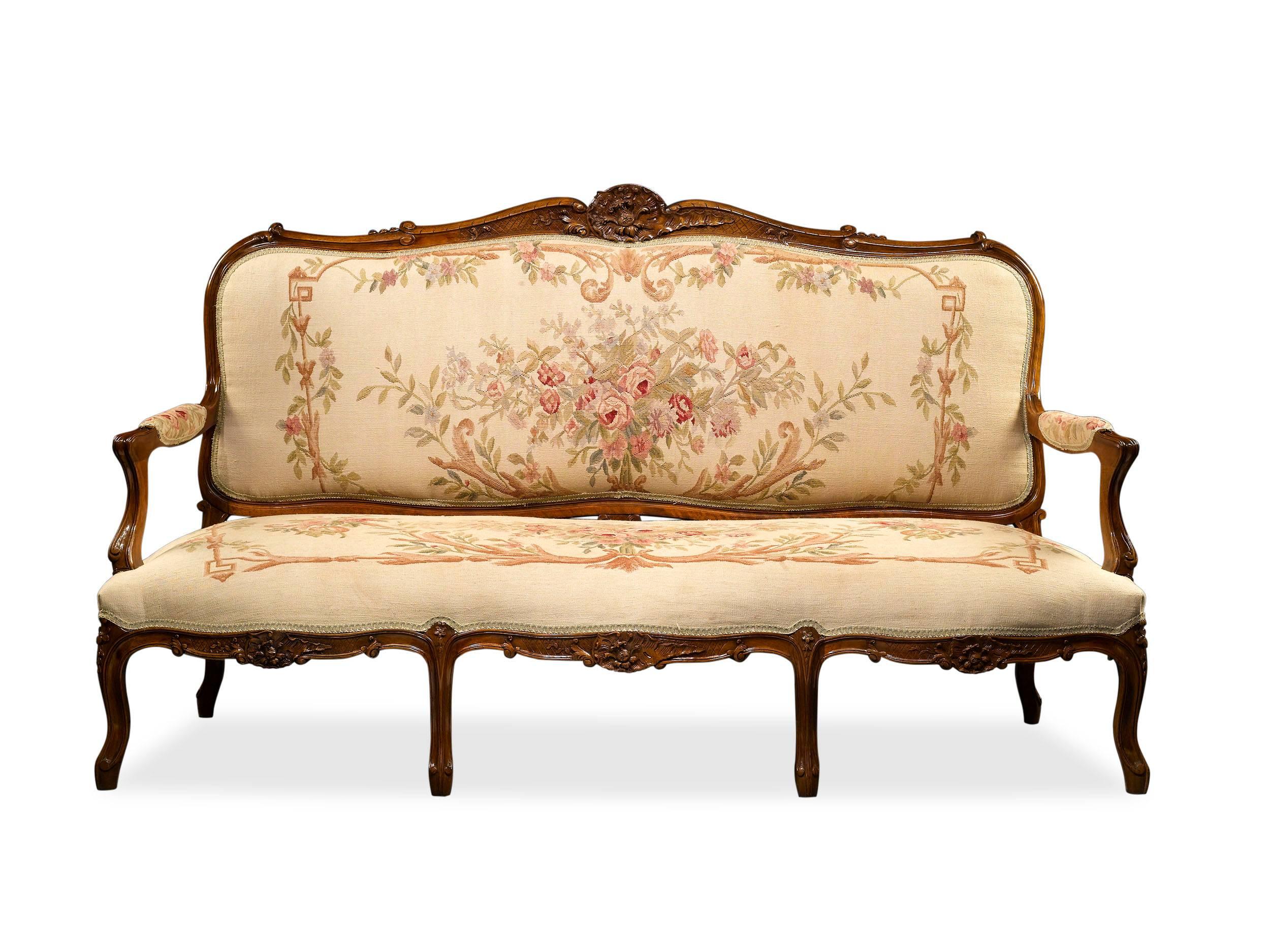 A magnificent five-piece carved walnut parlor suite in the Louis XV-style richly upholstered in exceptional and rare handwoven Aubusson tapestries. The set includes two armchairs, two side chairs and a canapé each finely carved with Rococo