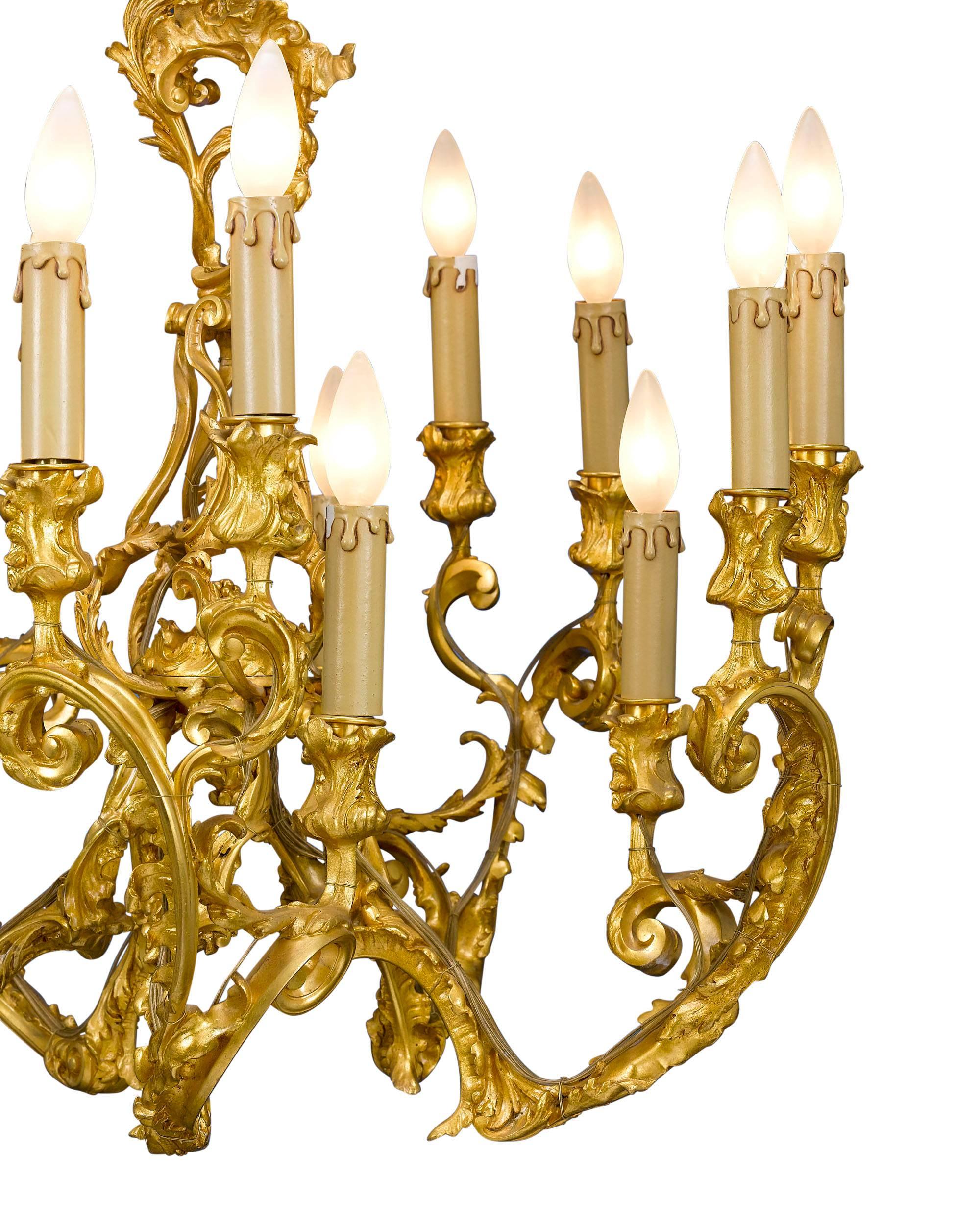 This stunning French bronze ormolu chandelier is almost certainly the work of artist Alexandre Charpentier. Crafted entirely of gilded bronze, this striking light is a masterpiece of the Rococo Revival style. A symphony of asymmetrical curves and