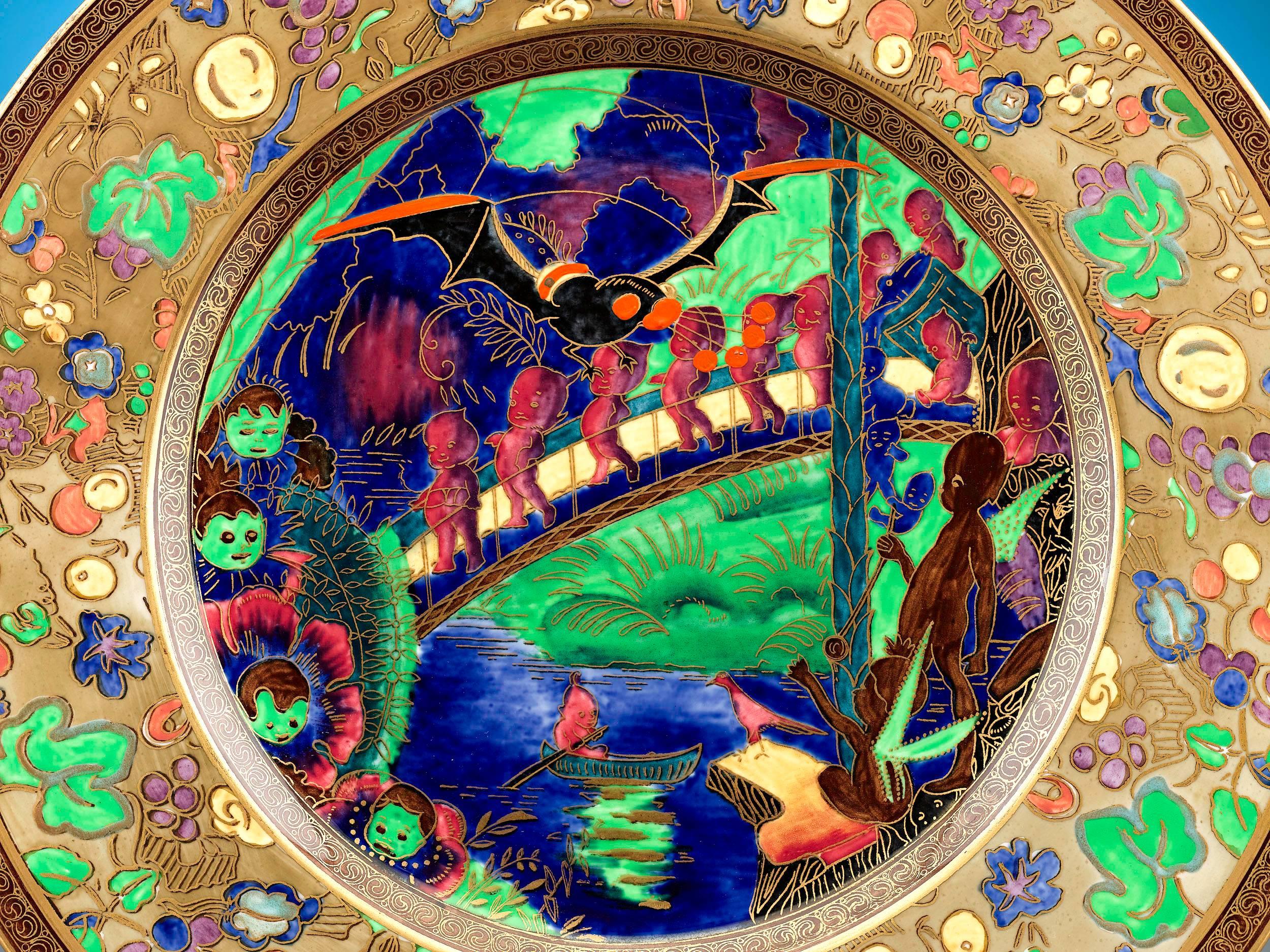 This captivating porcelain plate is a stunning example of the renowned Fairyland Lustre pattern by Wedgwood. The charming “Imps on a Bridge” motif is beautifully rendered on the body of the plate in bright greens, deep blues and lush reds, and
