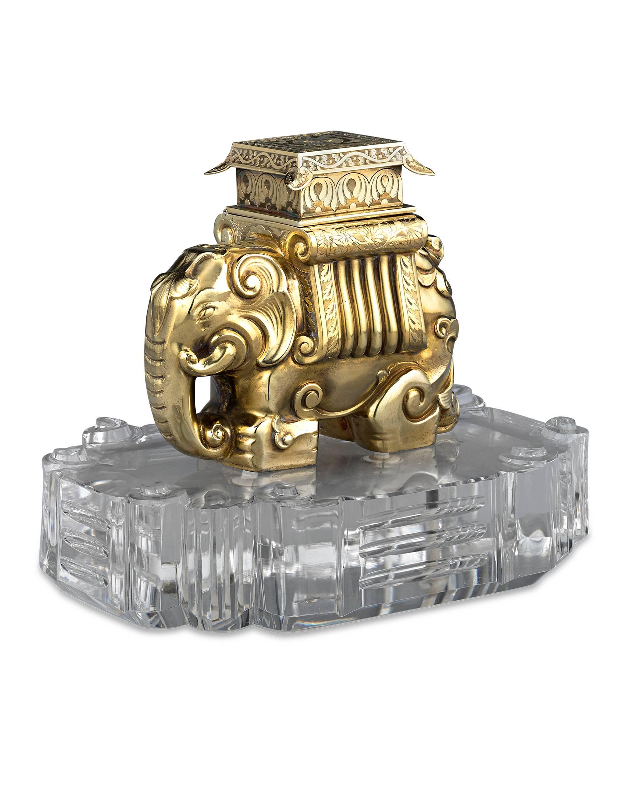 Both an opulent objet d'art and utilitarian accessory, this magnificent British inkwell takes the form of a silver gilt Indian elephant resting upon a base of carved rock crystal. This is a form of inkwell we have never seen before, and given the