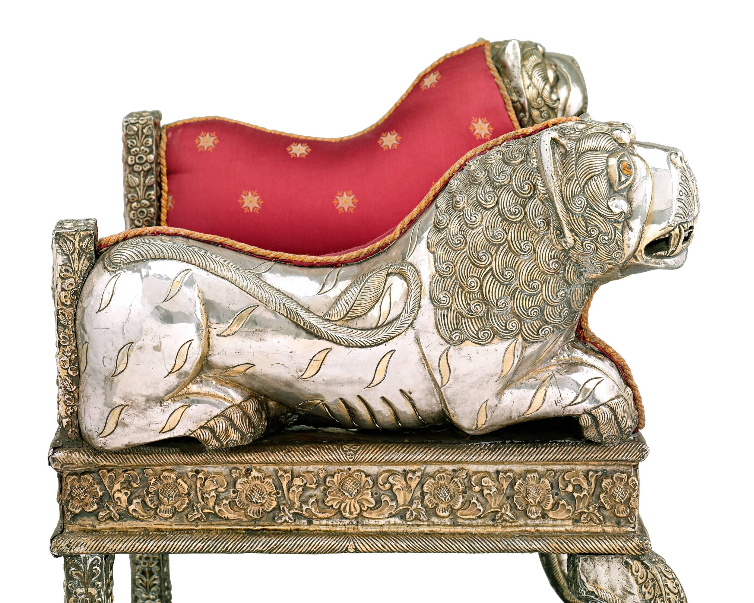 This rare Anglo-Indian silver chased seat is an elaborate and striking marriage of Western form with Eastern artistry. Covered entirely in marvellously worked silver with parcel gilding, the form of this chair is inspired by the English Regency