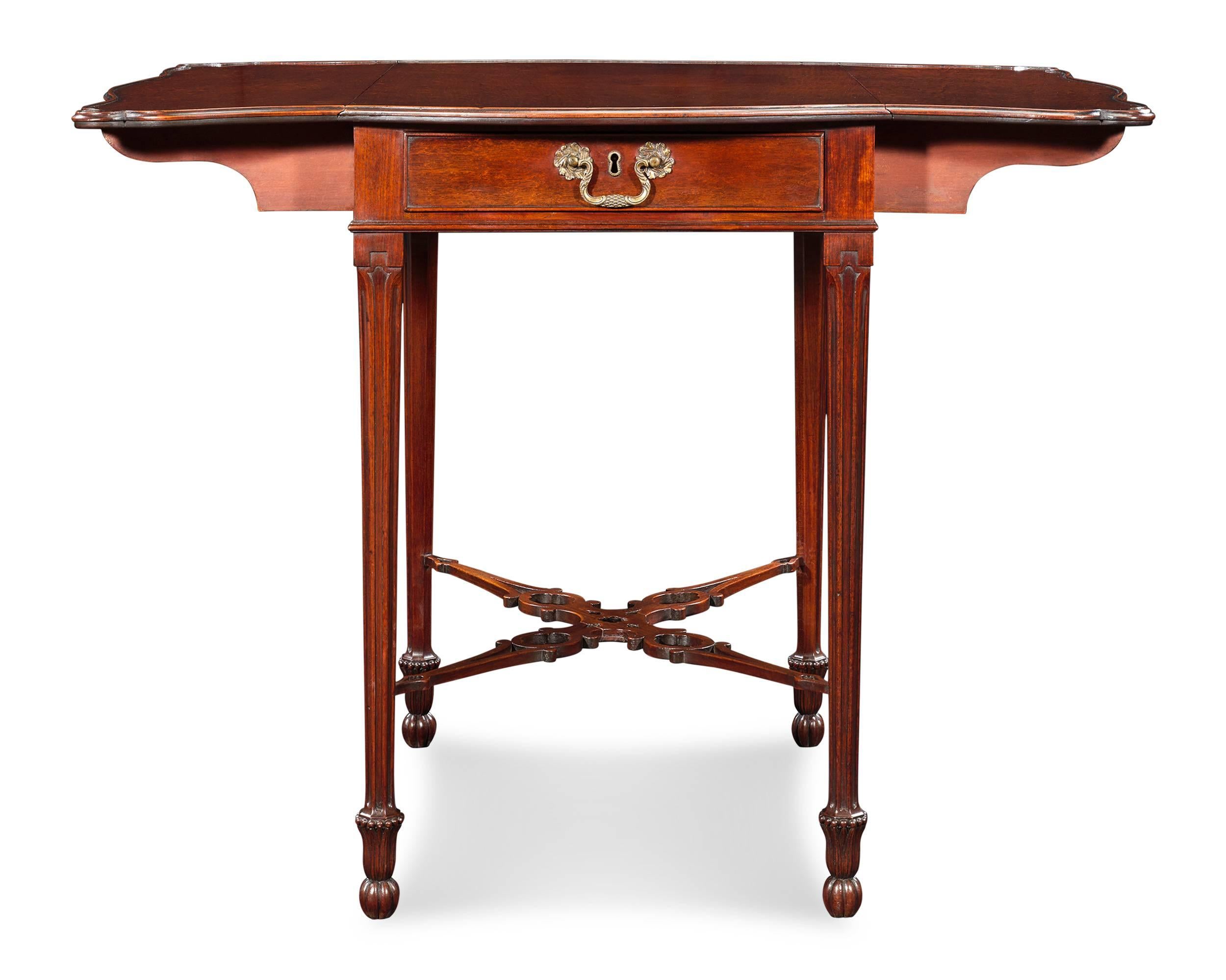 The exceptional craftsmanship of this English Pembroke table exemplifies the artistry and elegance of the Chippendale style. Crafted of Cuban mahogany, the table displays all of the aesthetic hallmarks of Thomas Chippendale's iconic designs. Of