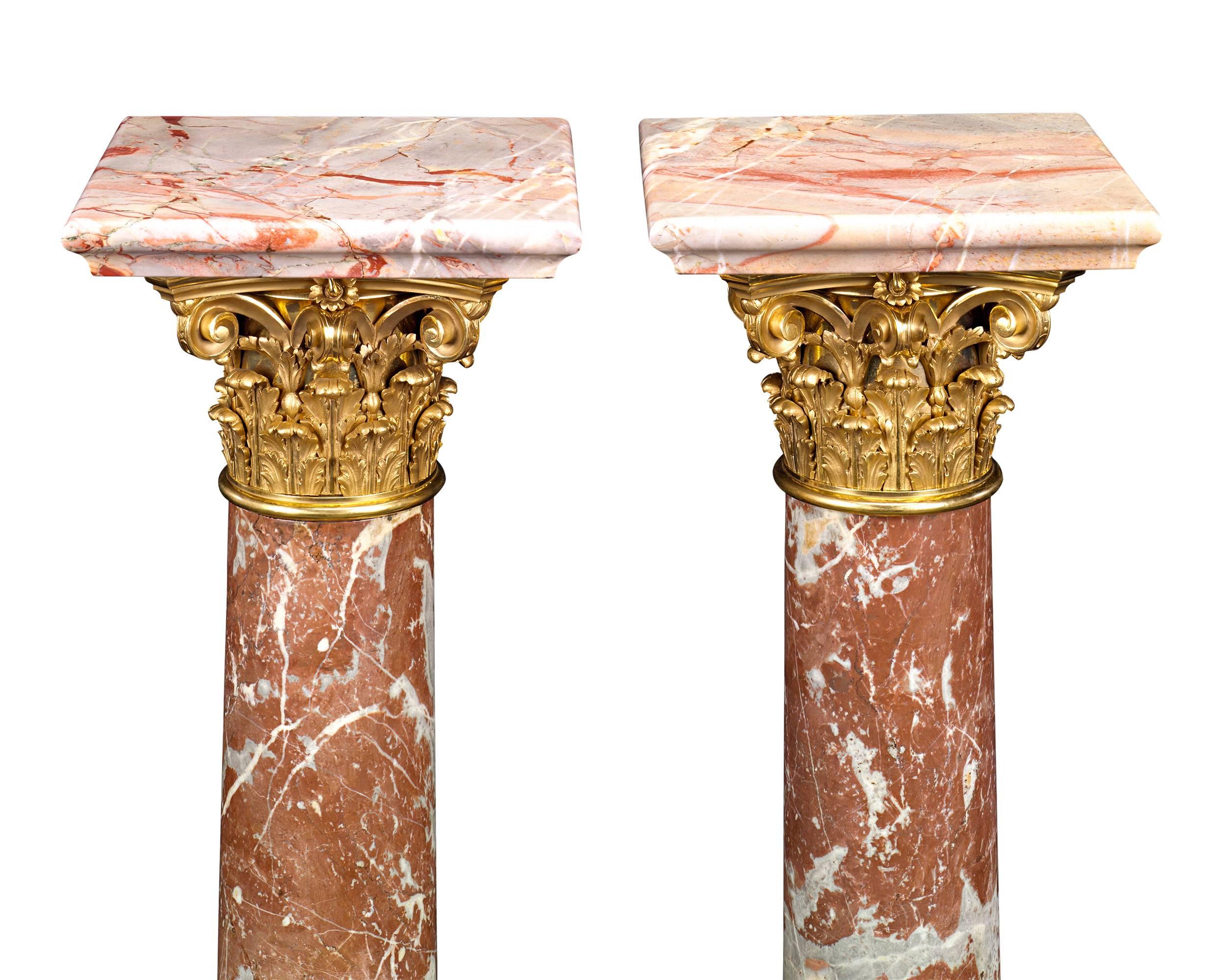 Four complementary varieties of marble were selected to create this stately pair of French Louis XVI-style pedestals. Crafted in the neoclassical form of Corinthian columns, the pedestals bring together rare specimens of rouge royale and rouge