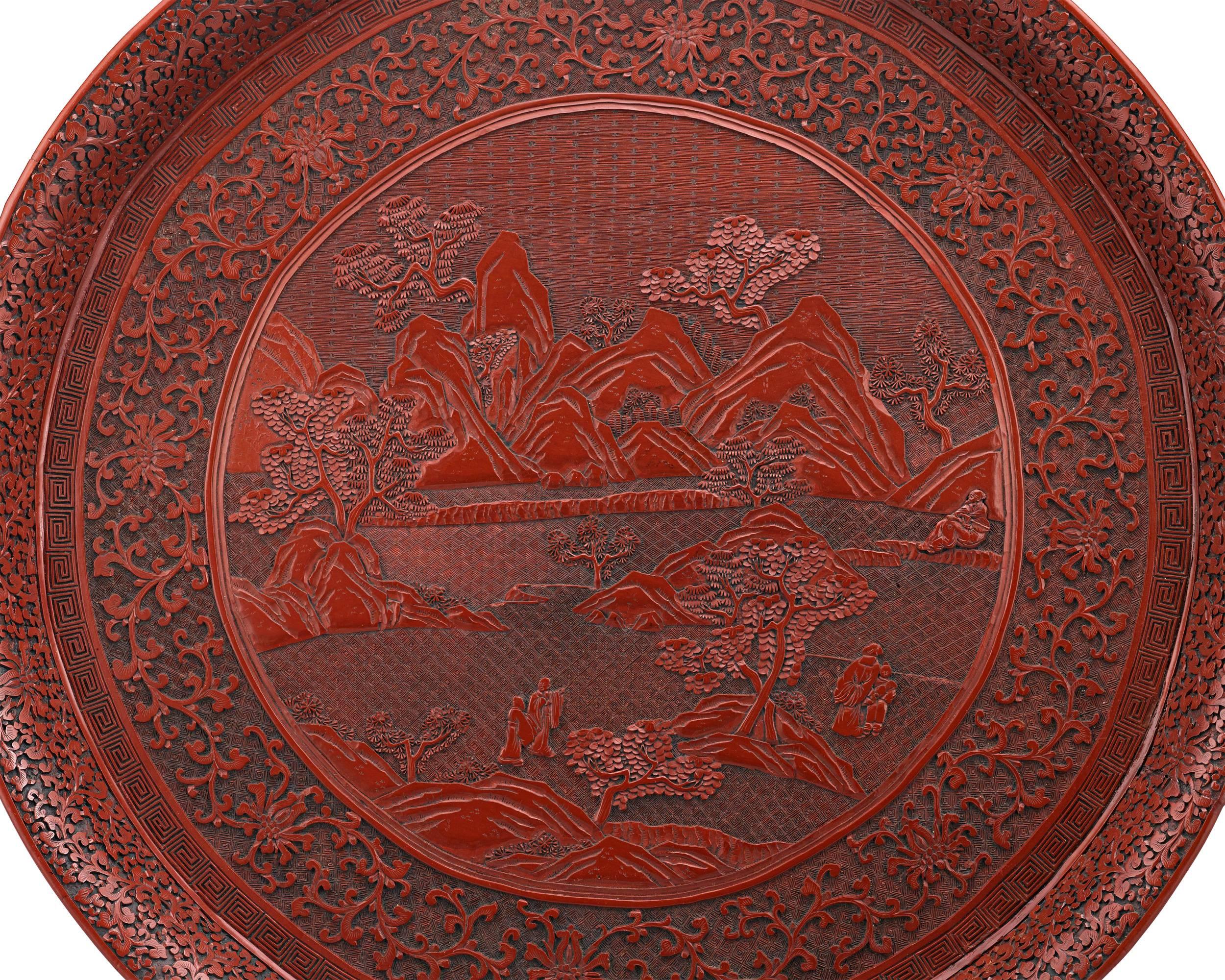 Exhibiting the highest level of detail, this extraordinary 18th-century tray is masterfully crafted from cinnabar lacquer in the ancient Chinese tradition. Enveloped in intricately carved and incised decorative motifs, the tray boasts the sculptural