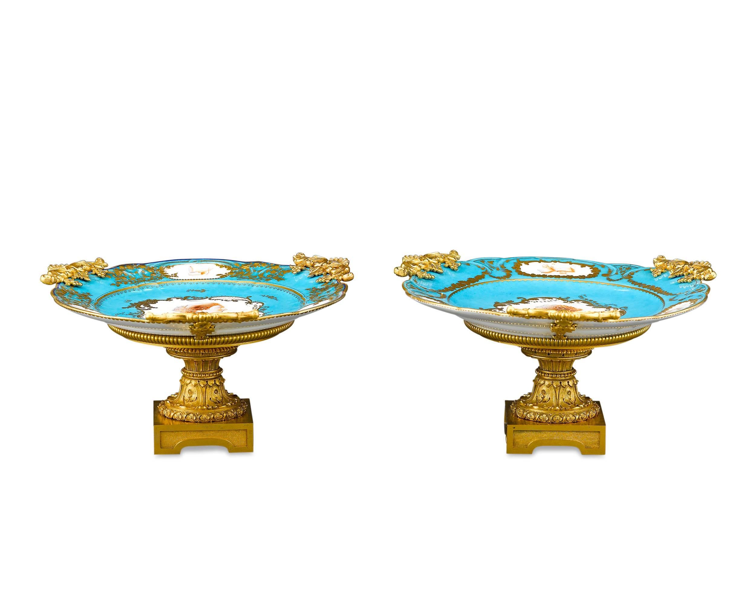 Two excellent Sèvres porcelain plates are mounted in bronze ormolu stands in these exceptional compotes. The delicate turquoise, or bleu celeste, hue provides the perfect background to exquisite portrait plaques of two ladies, surrounded by smaller