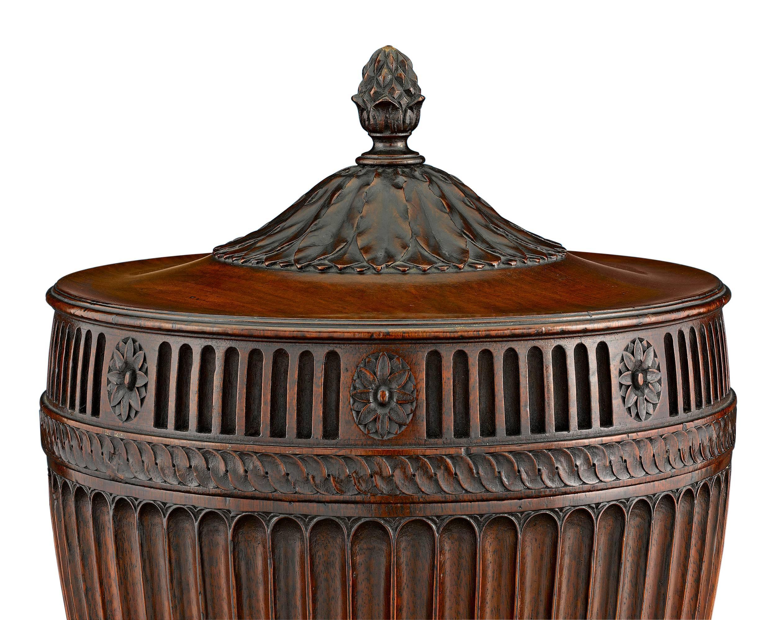 Exceptional carving and a rich, warm patina distinguish these rare George III-period mahogany urns. These Neoclassical vessels, highlighted by fluted, gadrooned, anthemion and acanthus motifs, feature their original spigots and linings. Most likely