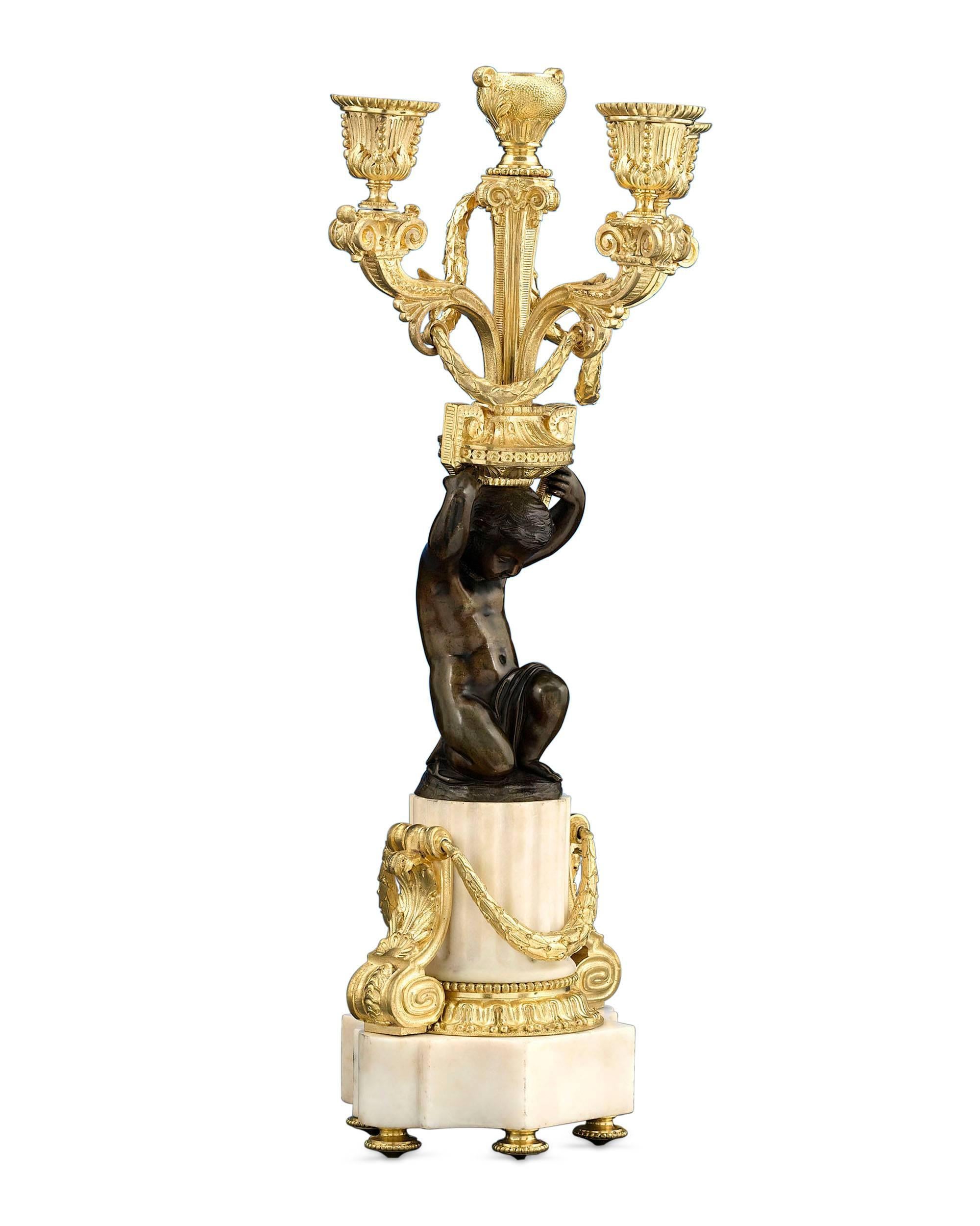 This exceptional pair of French Louis XVI-style marble and bronze candelabra exhibit the timeless neoclassical style of the late 18th century. The classical boldness and elegance of this aesthetic period is clearly evident in these monumental