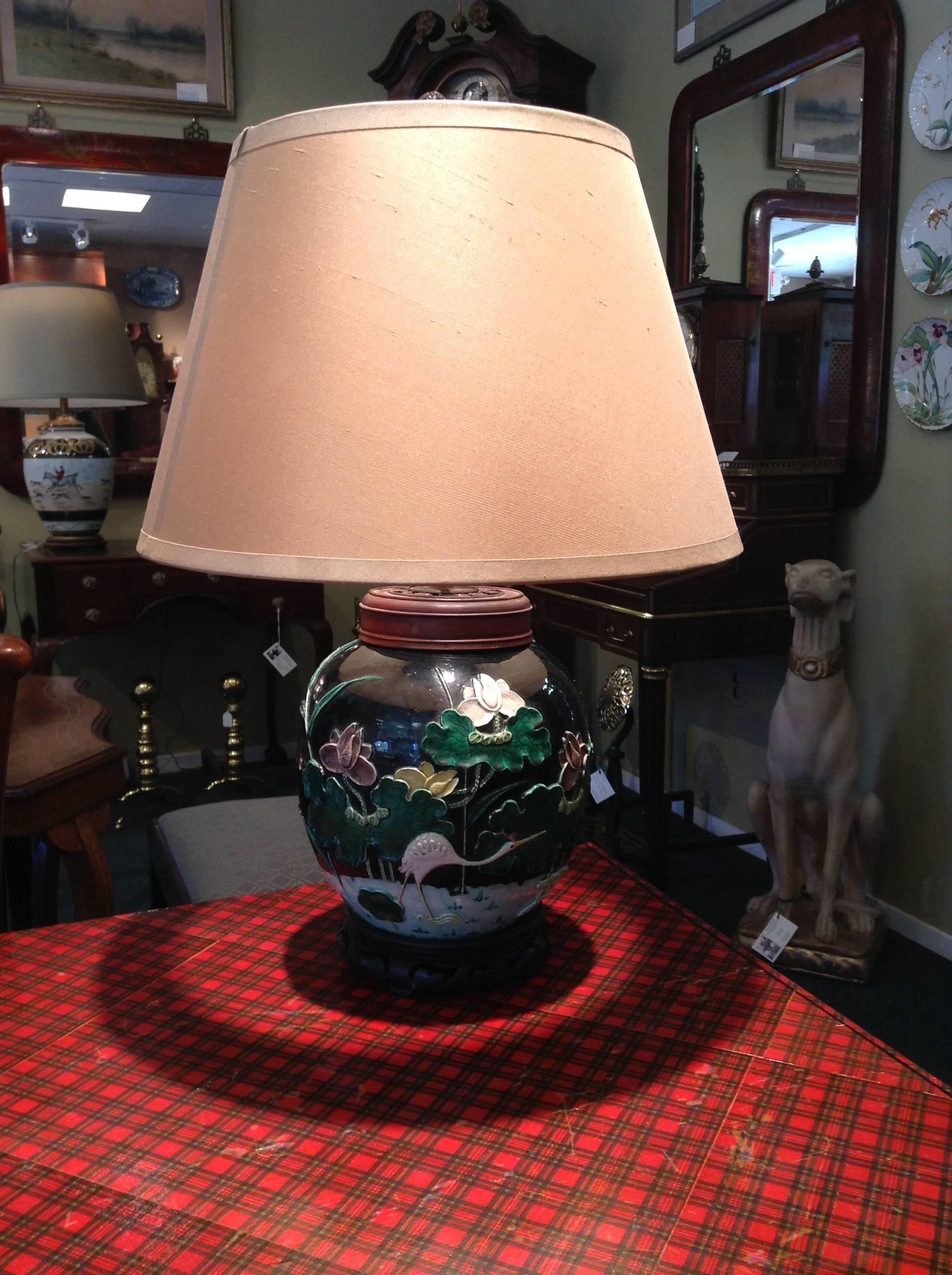 Rare pair of black 19th century Chinese lotus blossom and crane design lamps. 
These lamps have been originally made from ginger jars and decorated in the slip flow design with lotus blossoms and a crane. Beautiful design and coloring!

The