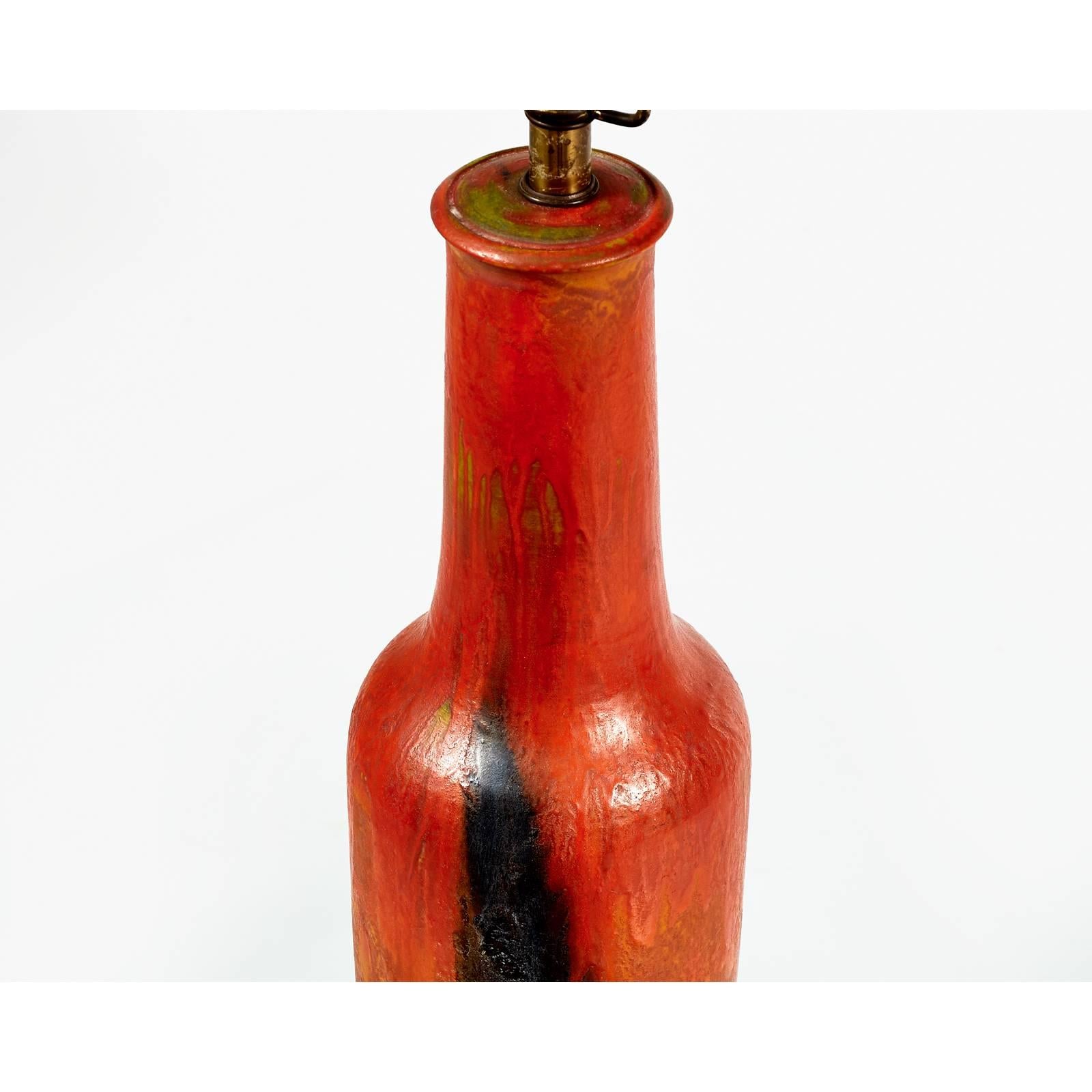 You are viewing a very rich looking and handmade fired Italian pottery lamp with reddish orange, green and black hues, circa 1950s-early 1960s. This particle lamp was acquired in Westchester, N.Y. from a designers home that included Mid-Century