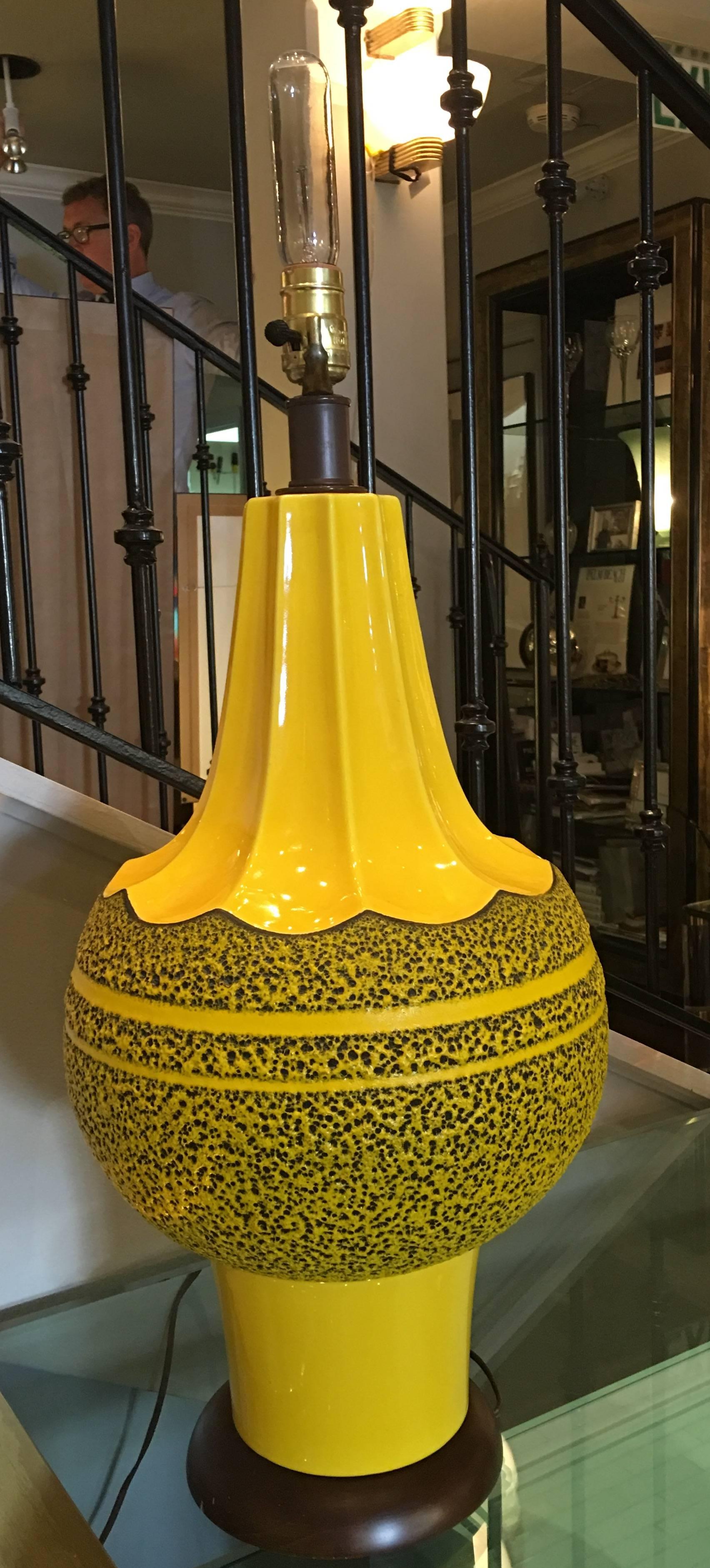 Large scale yellow ceramic lava lamp with wood base and red lamp shade, circa 1960.