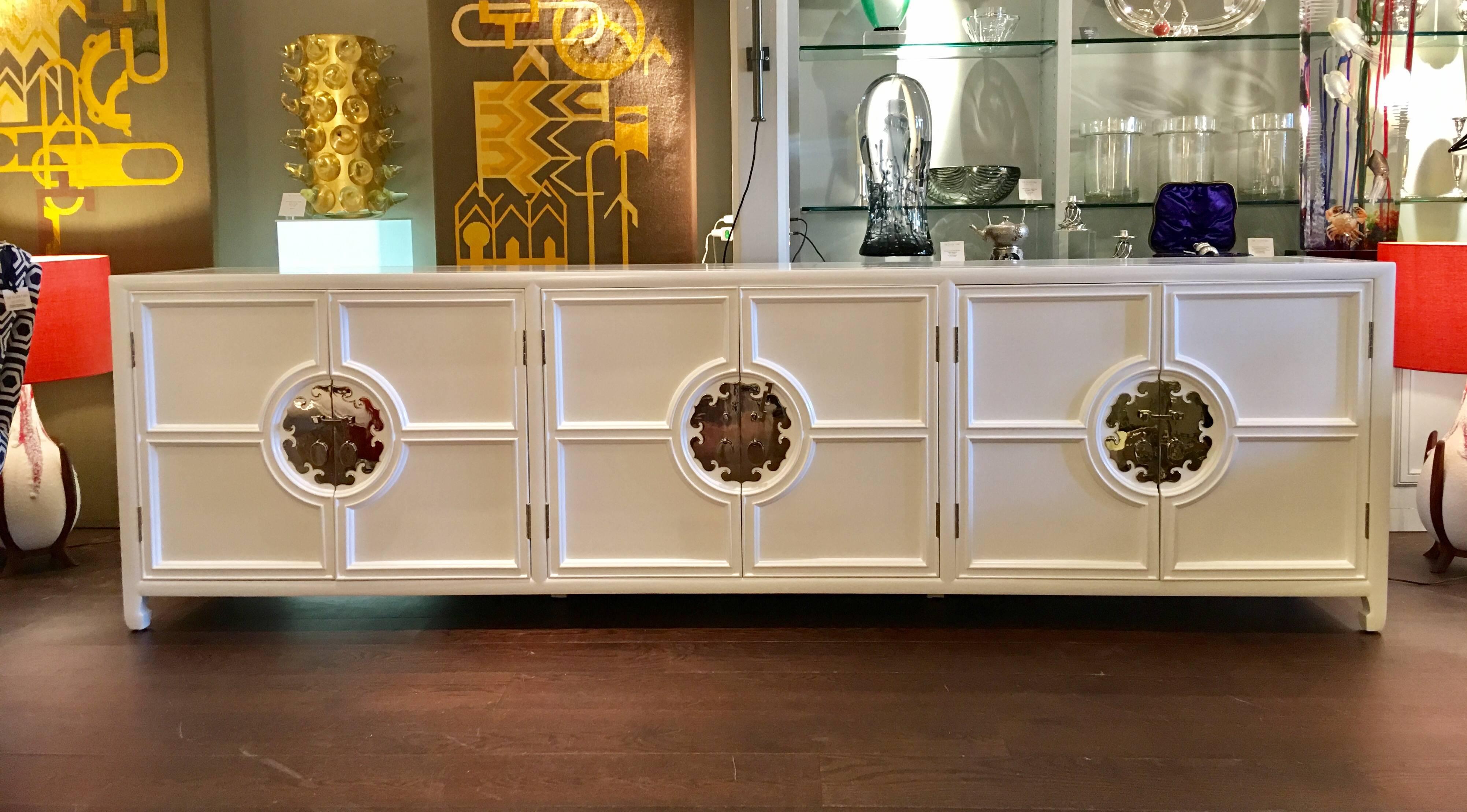 Large-scale white lacquered credenza with chrome handles in the style of Mastercraft, circa 1970s.