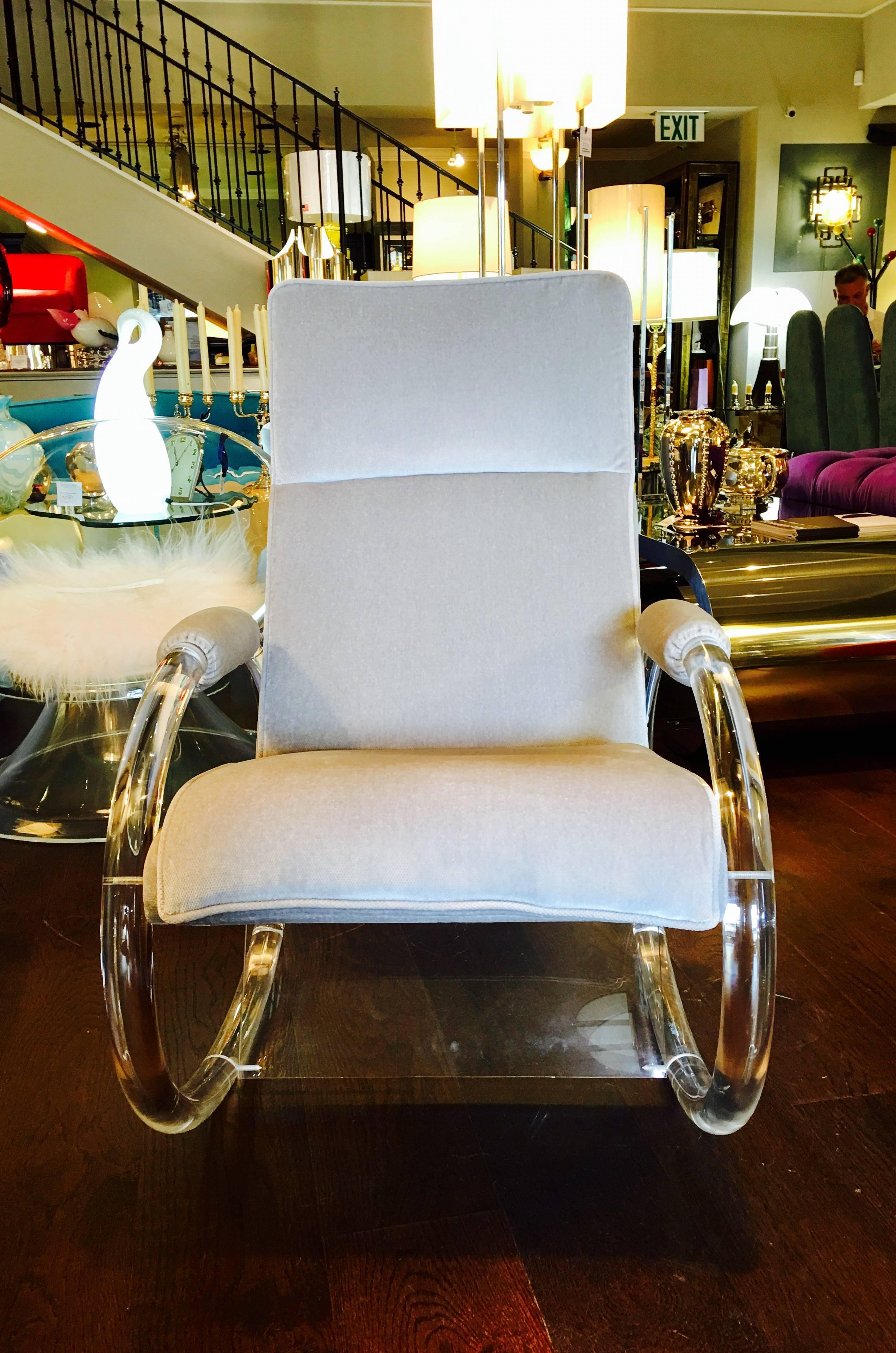 Lucite rocking chair by designer Charles Hollis Jones, upholstered in a light grey fabric with sculptural oval arms and Lucite base.