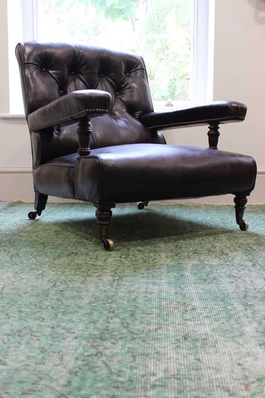 A fine quality and of great proportions, 19th century English Howard and Sons Ltd. Armchair having been reupholstered in leather, with the original stamped brass castors and back leg. This very comfortable library armchair will work well in most