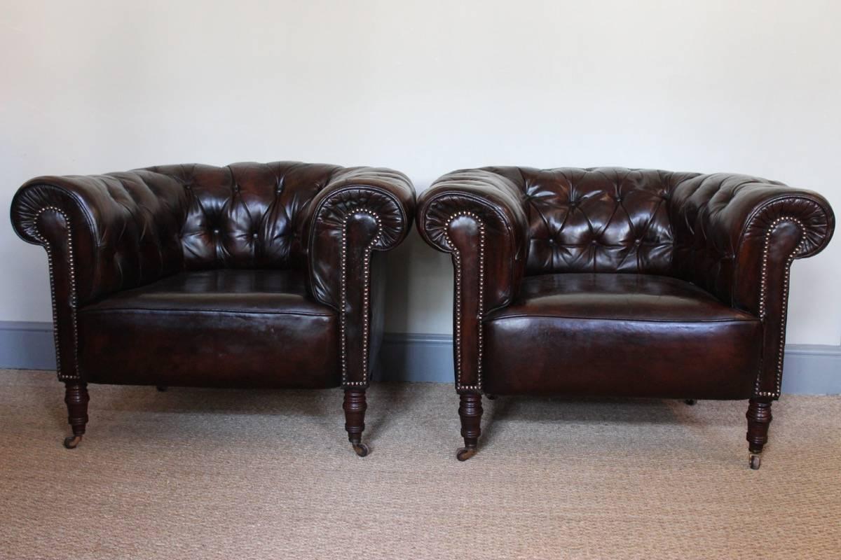 A good and comfortable pair of Chesterfield type club armchairs in their original deep-buttoned brown leather, with original castors, English, circa 1900s.
   