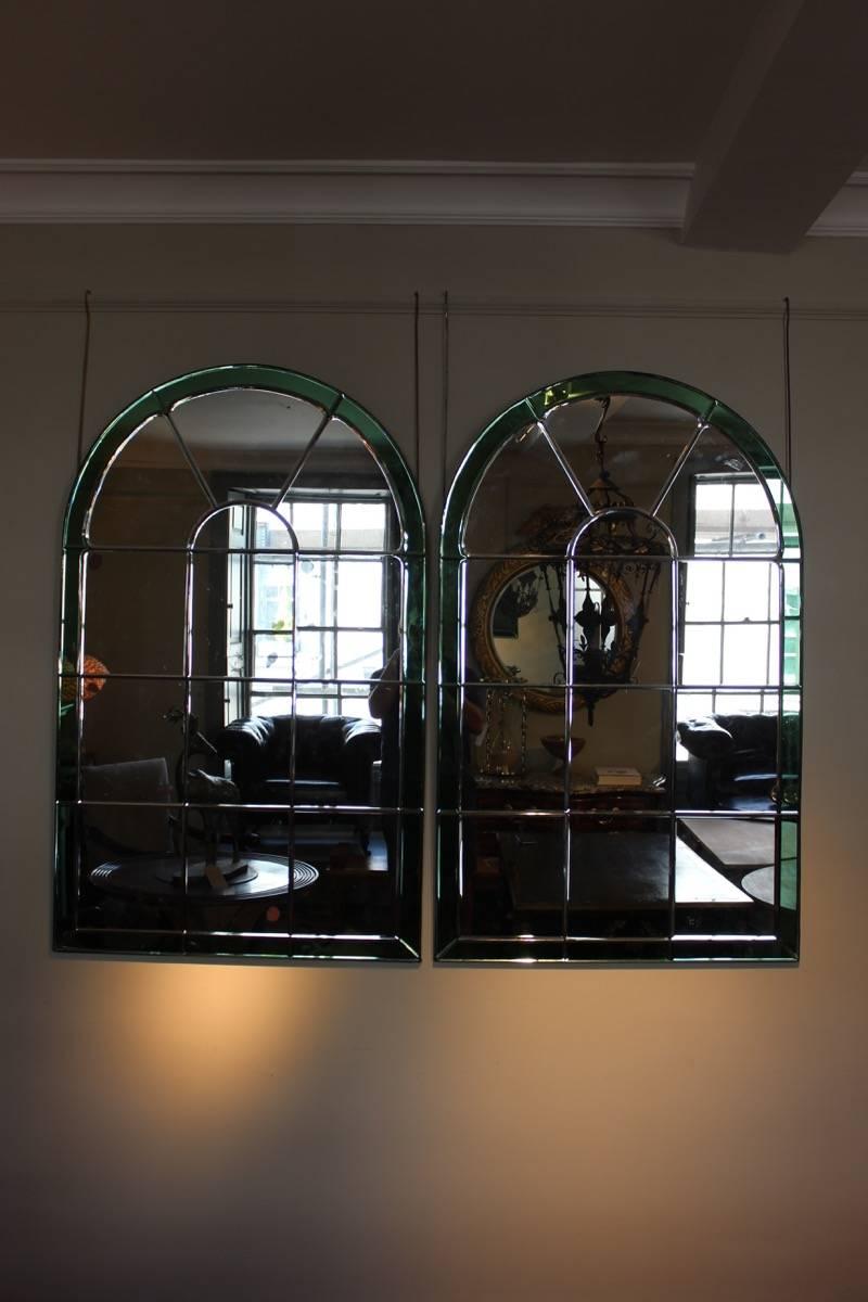A decorative pair of 1970s Venetian-style mirrors of architectural form with green colored marginal plates.