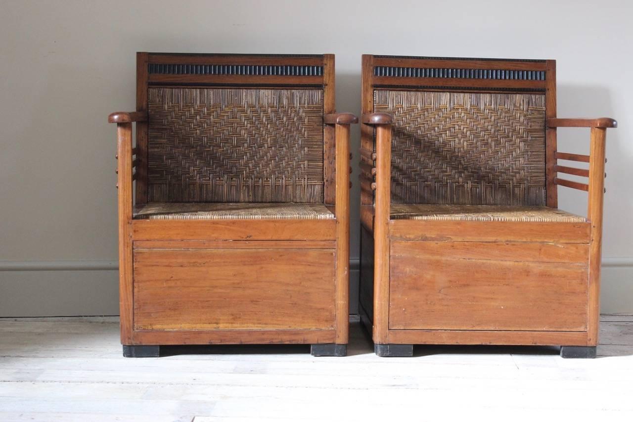An interesting pair of circa 1930s Colonial-style teak and ebonised armchairs, each with a caned back and seat.
     