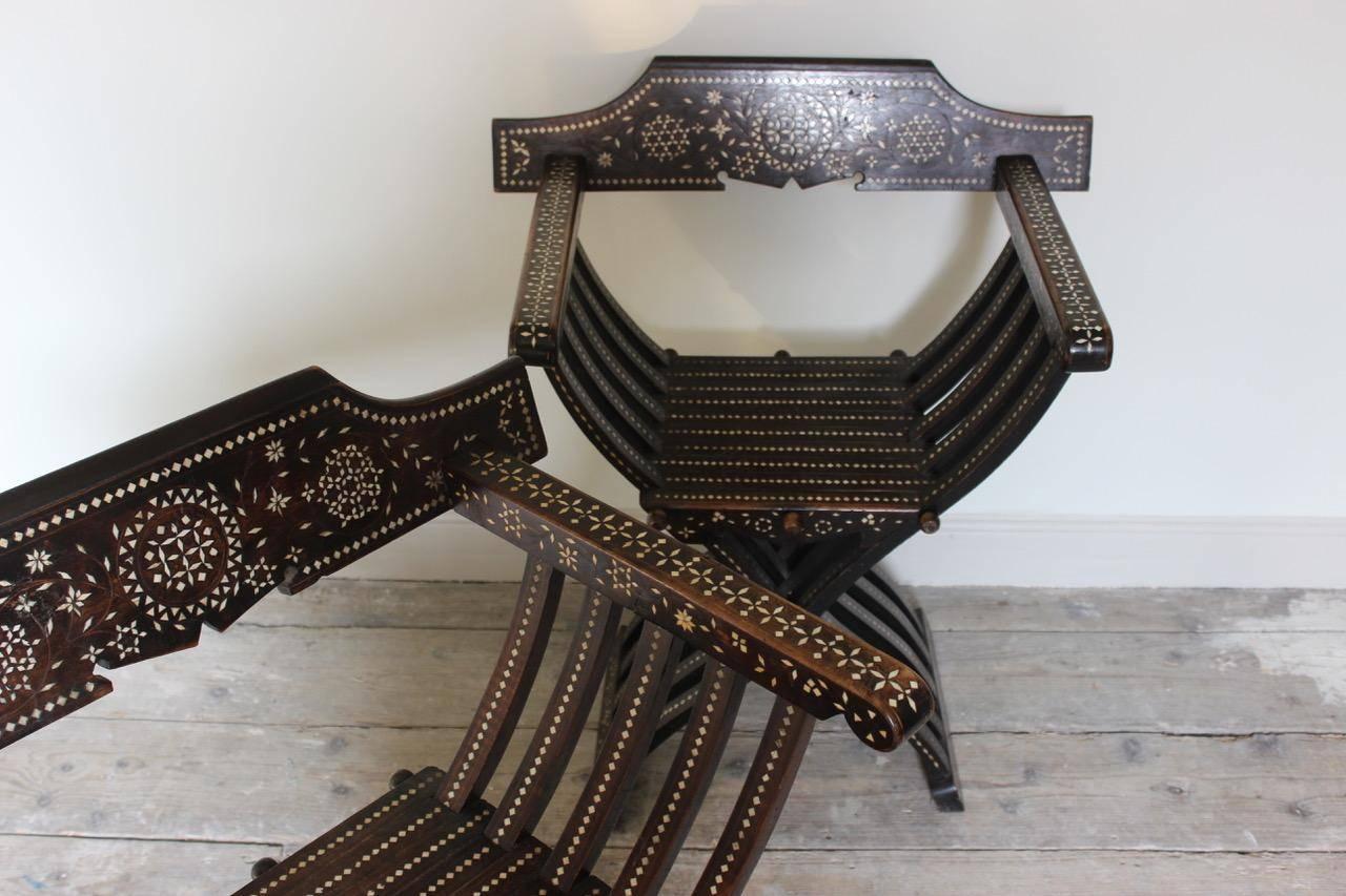 A good and decorative pair of late 19th century Spanish walnut with bone inlay armchairs, following the Moorish influence, that will make a statement in most settings.