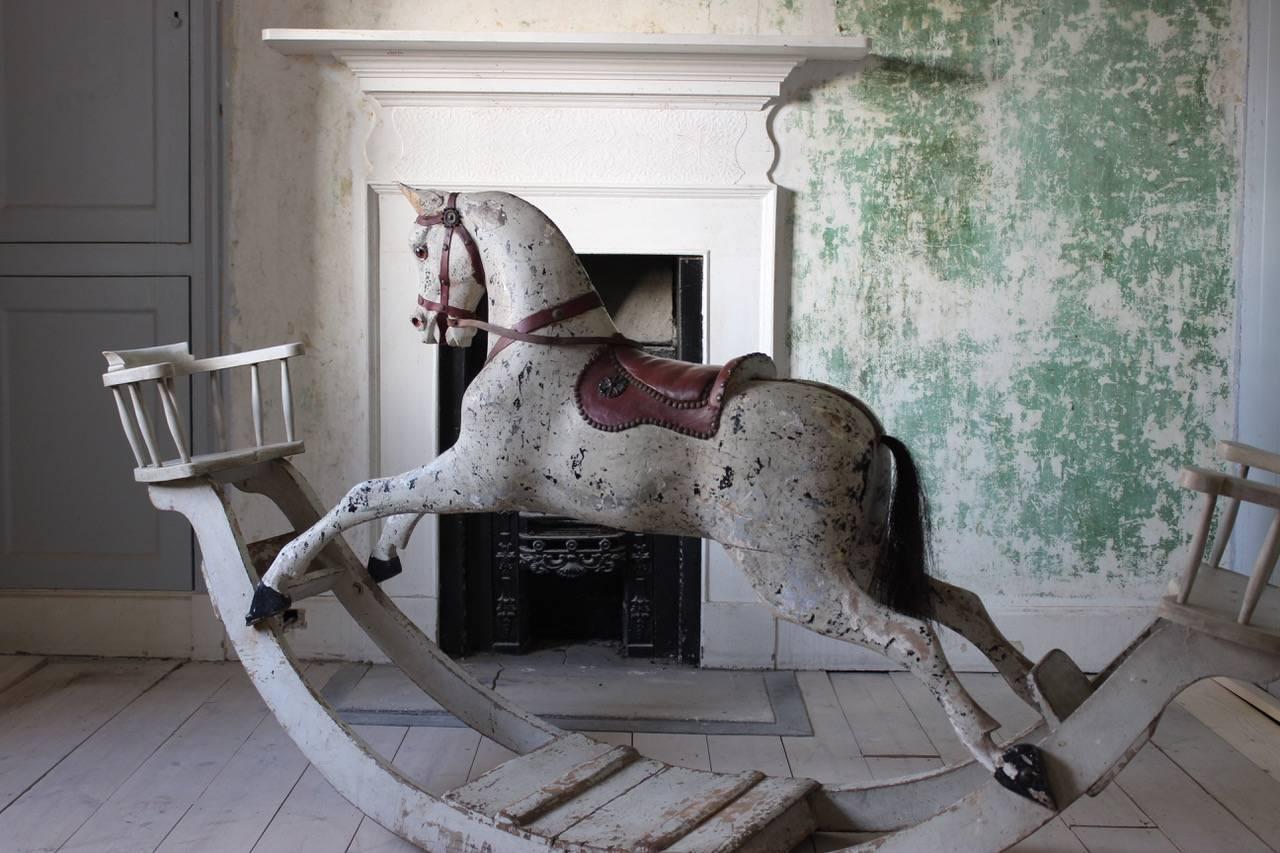 A superb and large, late 19th century English country house rocking horse with chairs at both ends, retaining the original paint. The finely-shaped body and details of this horse are reminiscent of the work of F.H. Ayres, a London based firm that